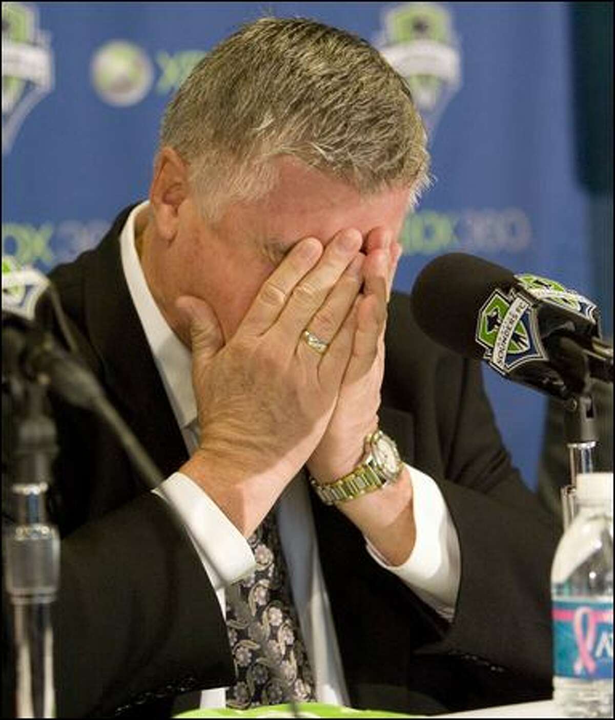 At Tuesday's press presentation, an emotional Sigi Schmid buries his face in his hands while talking about being the Sounders FC's first head coach and managing the team in the same city where his brother Roland lives with his family.