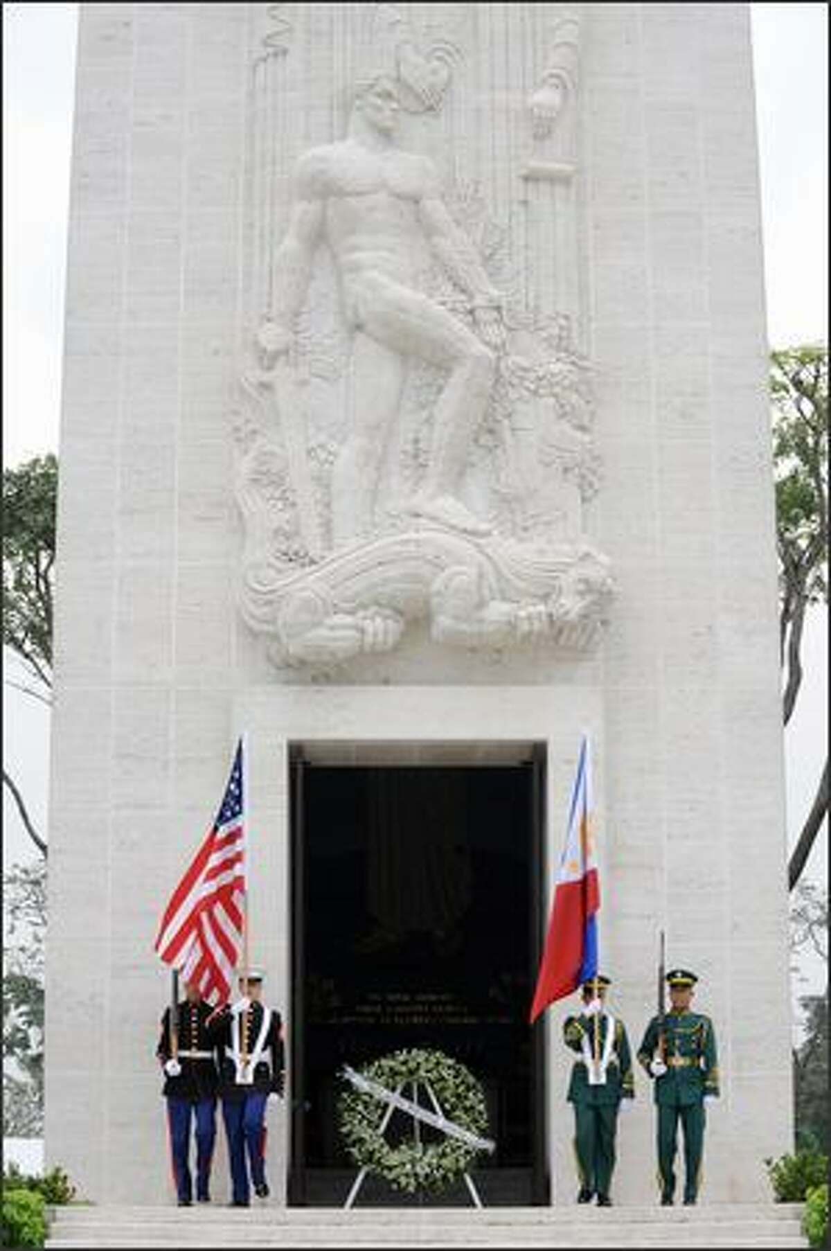 Philippine and U.S. military honor guards carry the flags of the Philippines and the U.S. at the war memorial at Manila American Cemetery during the annual Veterans' Day ceremony in Manila on Tuesday. The Veterans' Day mark the end of hosilities of World War I when the Armistice was signed November 11 -- the eleventh hour of the eleventh day of the eleventh month in 1918.