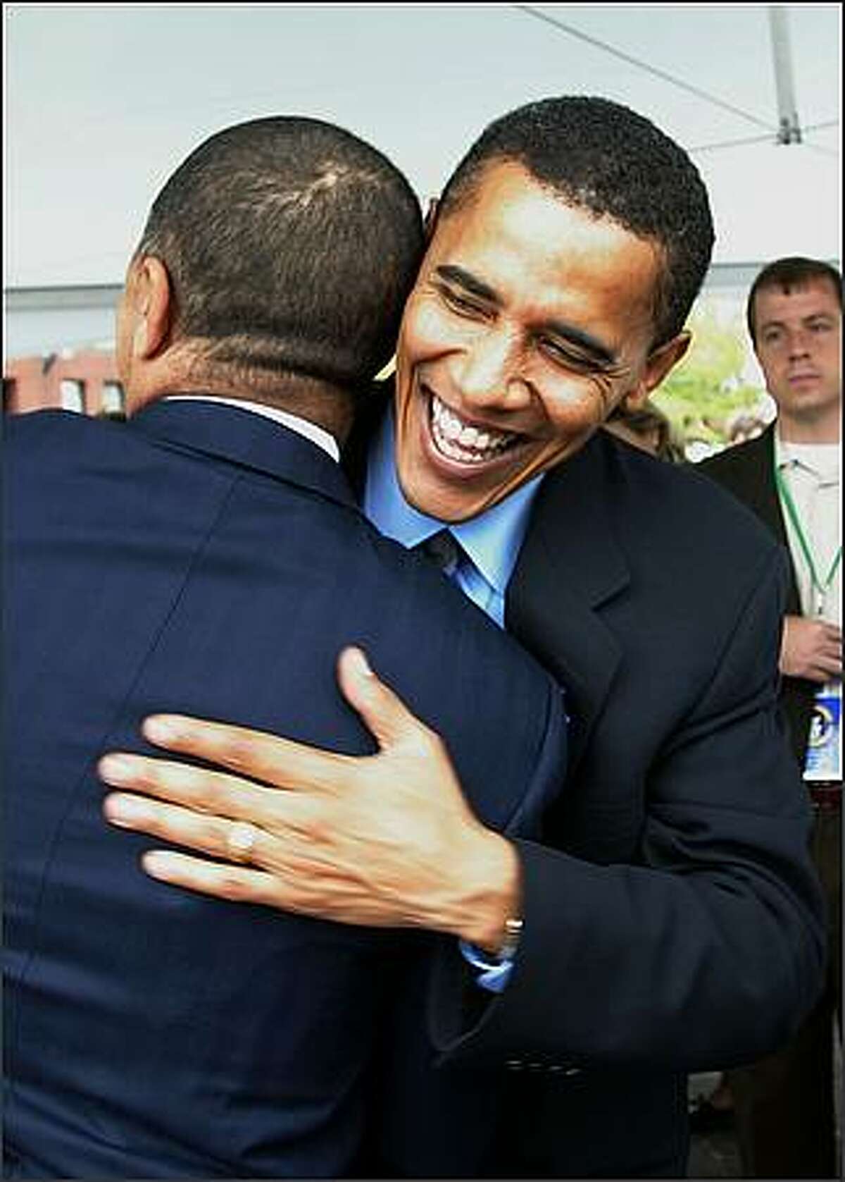 July 27, 2004. Democratic Convention Keynote speaker and Illinois Senate candidate Barack Obama hugs a supporter before speaking at the League of Conservation Voters Environmental Victory Rally at Christopher Columbus Park in Boston, Massachusetts. Democratic presidential candidate U.S. Senator John Kerry (D-MA) is expected to accept his party's nomination later in the week. (Photo by Mario Tama/Getty Images)