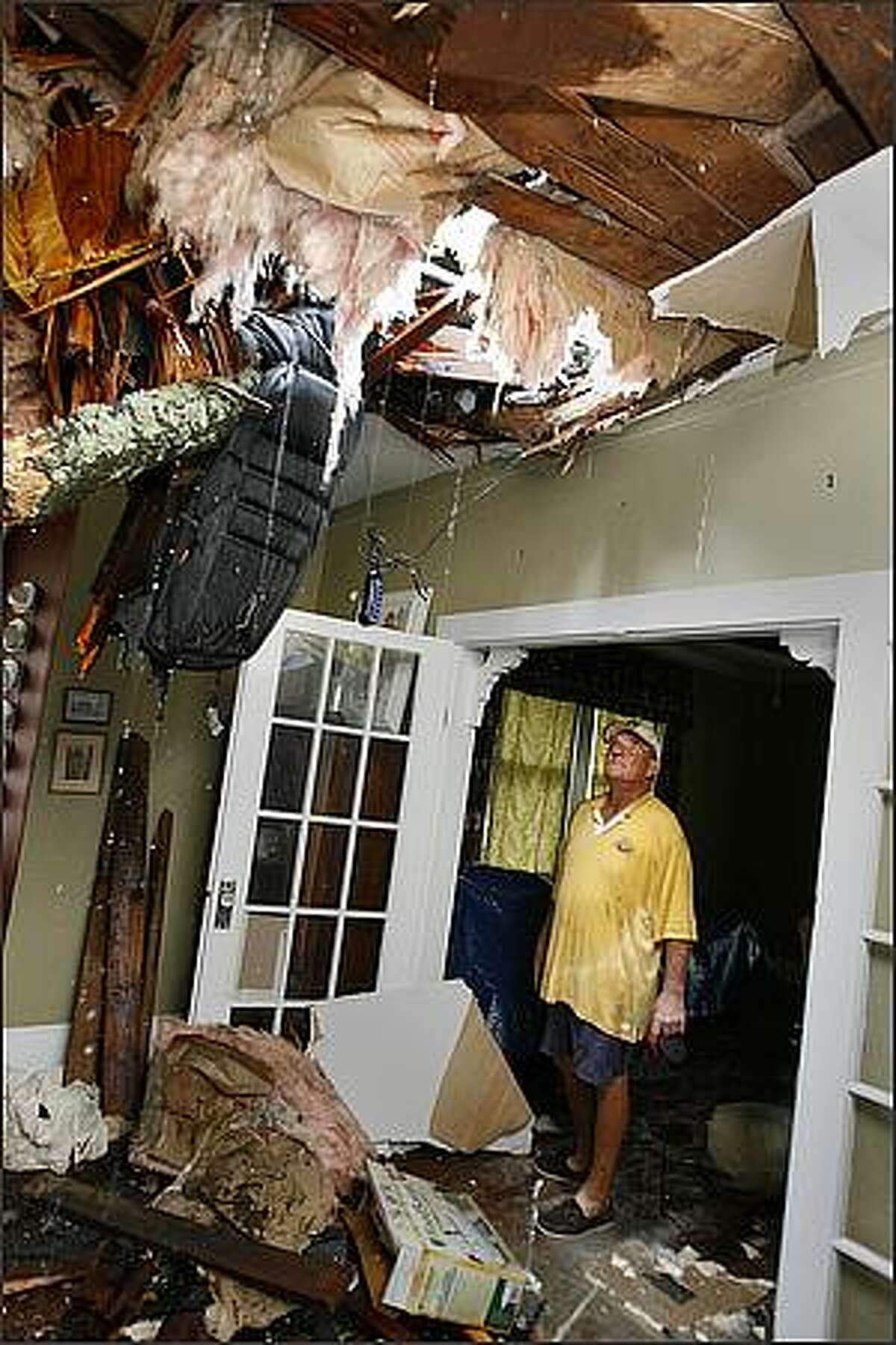 Richard Bezet looks over damage to the living room of his Baton Rouge, La., home after a tree fell through the roof due to winds from Hurricane Gustav. Kathy Anderson/AP/The Times-Picayune