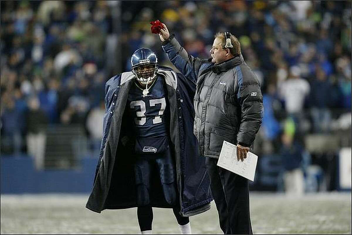 Head coach Mike Holmgren of the Seattle Seahawks holds the red challenge flag as running back Shaun Alexander #37 looks on against the Green Bay Packers on November 27, 2006 at Qwest Field in Seattle, Washington. The Seahawks defeated the Packers 34-24. (Photo by Otto Greule Jr/Getty Images)