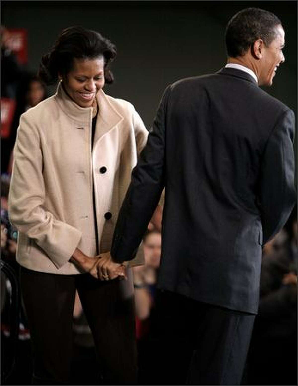 Democratic presidential hopeful Sen. Barack Obama (D-IL) (R) holds hands with his wife Michelle Obama during a rally at the athletics facility at Dartmouth College Jan. 8, 2008 in Hanover, New Hampshire. Polls show Obama leading Sen. Hillary Clinton (D-NY) moving into today's New Hampshire primary.