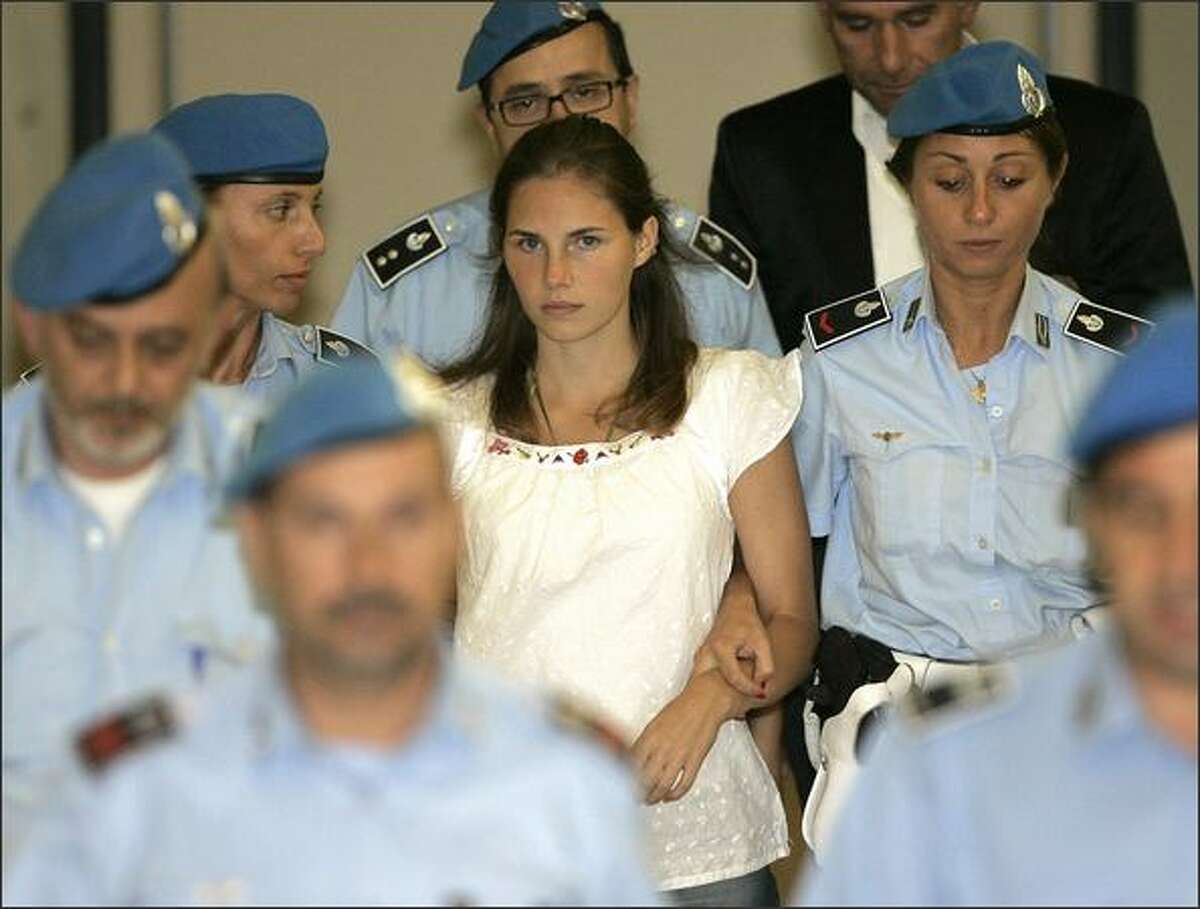 American murder suspect Amanda Knox, center, is escorted by Italian police officers from Perugia's court after a hearing in central Italy last September. Knox, along with her former Italian boyfriend, Raffaele Sollecito, and Rudy Hermann Guede, are suspects in the November 2007 slaying of British exchange student Meredith Kercher.