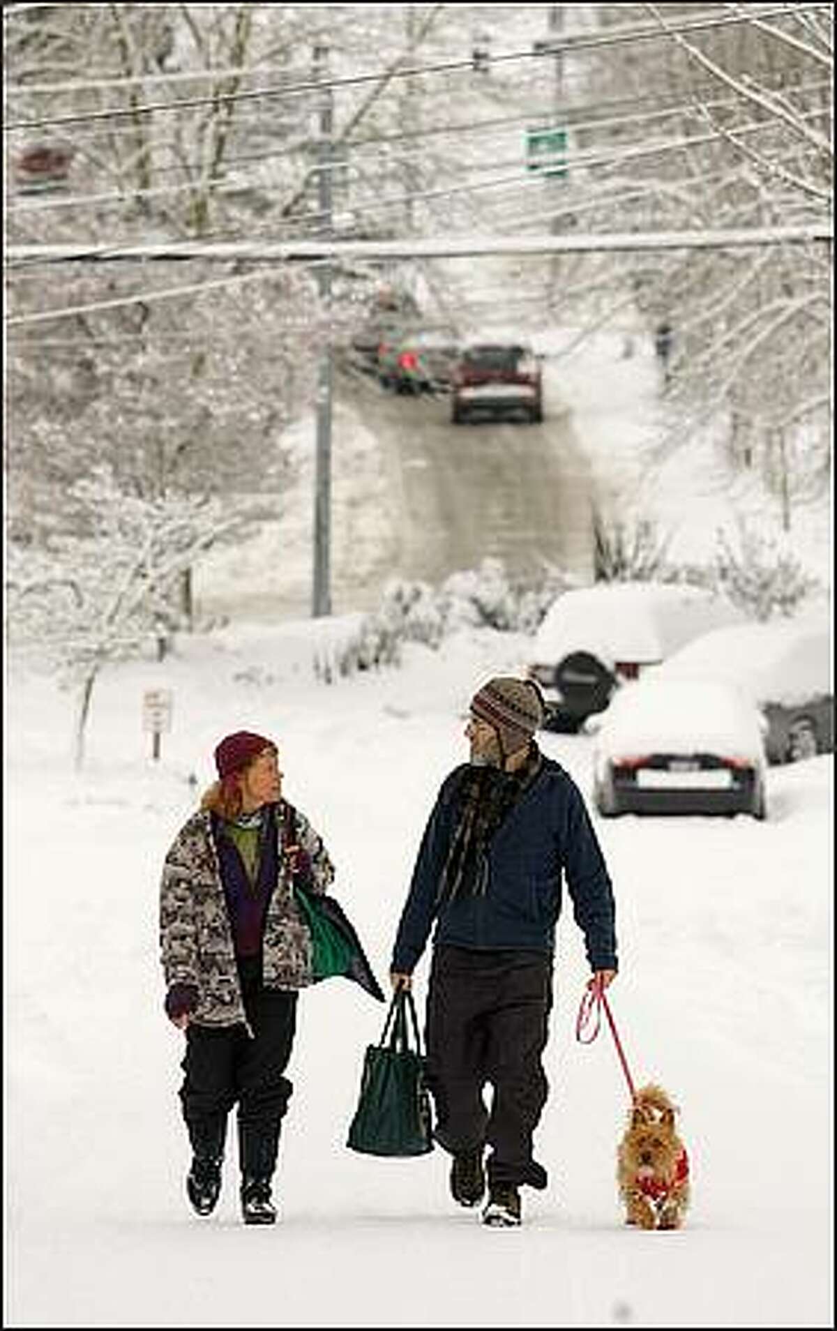 Margaret and Kurt Vance work on their harmonies while walking back to their Wallingford home after getting coffee at a dog-friendly Fremont neighborhood coffee house. With them is Penny, whom they are dog-sitting. The Vances, who sing in their church choir, just took part in a Christmas caroling party, despite the weather. They say that singing together is good for their marriage.