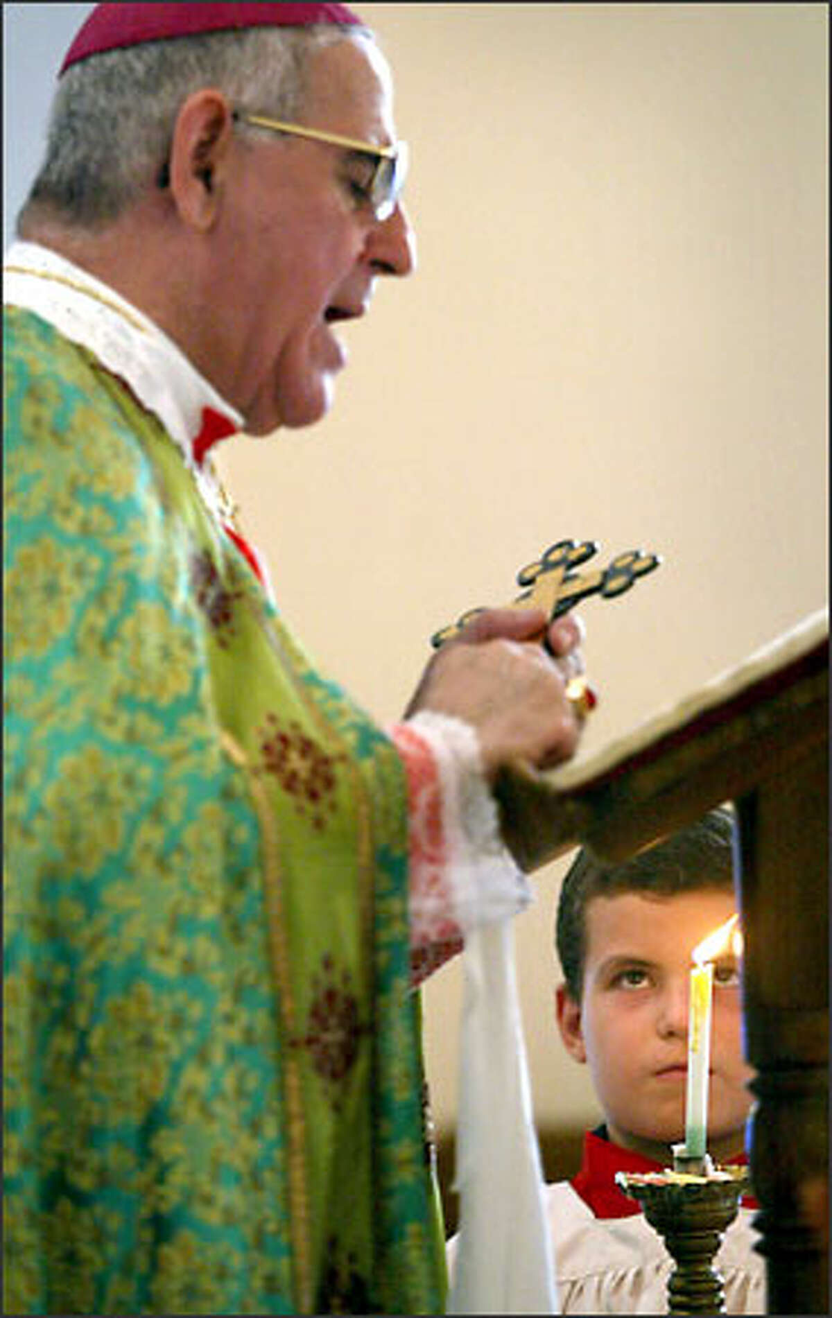 Altar boy Farj Khaleed, 11, assists Archbishop Djibrael Kassab during Mass in Basra. When war broke out in Basra, most Christians left the city, as they did in the first Gulf War. Only now some of them are returning, Kassab said.