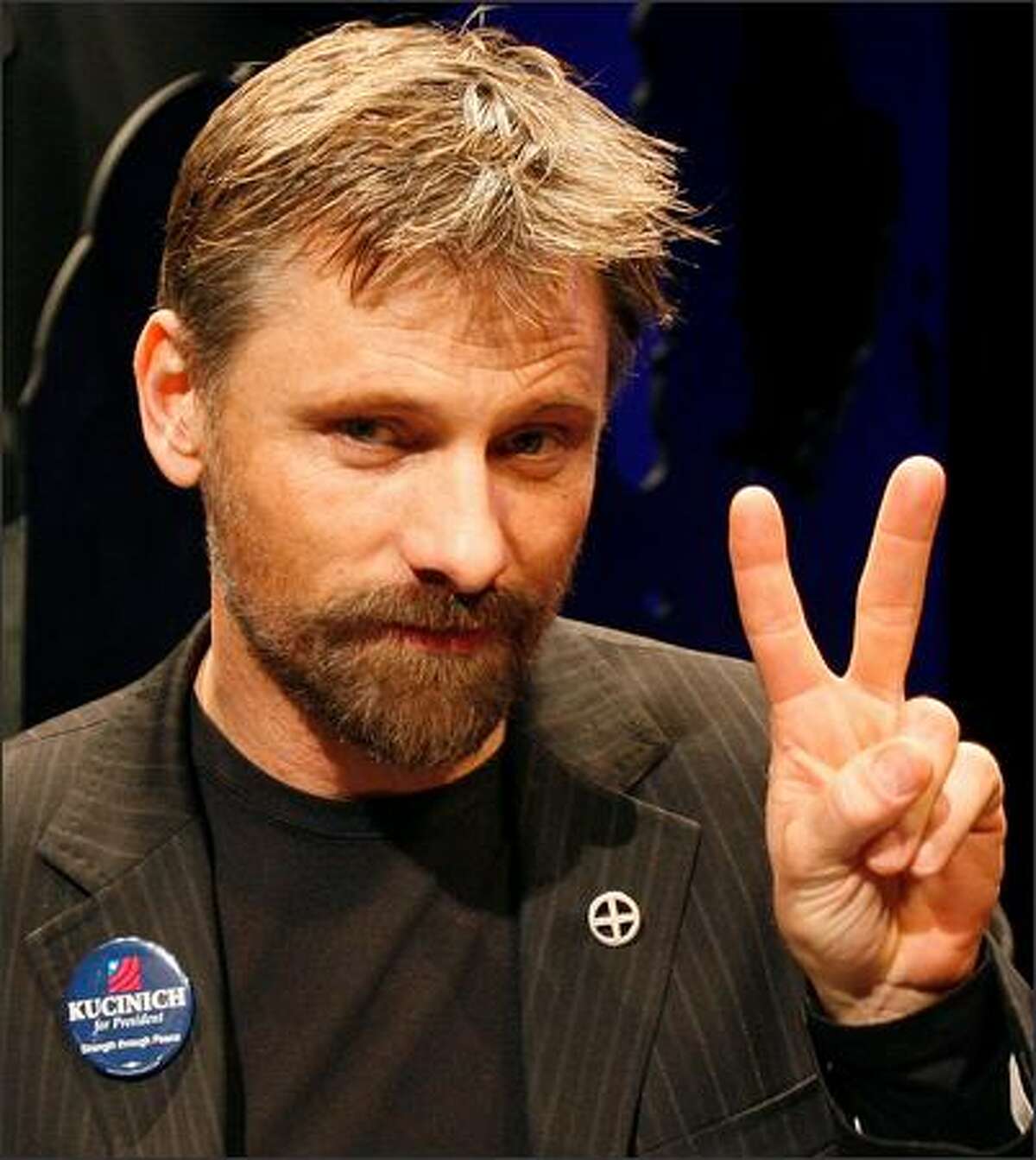 Actor Viggo Mortensen makes a peace sign before the start of a panel discussion about an upcoming mini-series entitled "The People Speak", Jan. 9, 2008, at Emerson College in Boston. Production of the series, which is an adaptation of the book by Howard Zinn, began in Boston on Jan. 8 and will continue throughout the Spring. (AP Photo/Michael Dwyer)