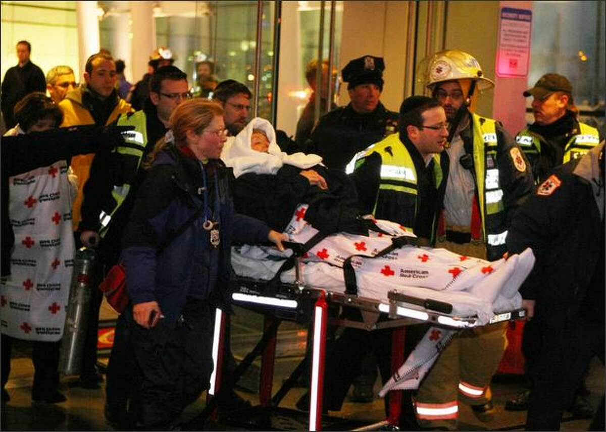 A passenger of US Airways flight 1549 is carried out on a stretcher from a Hudson River terminal in New York City.