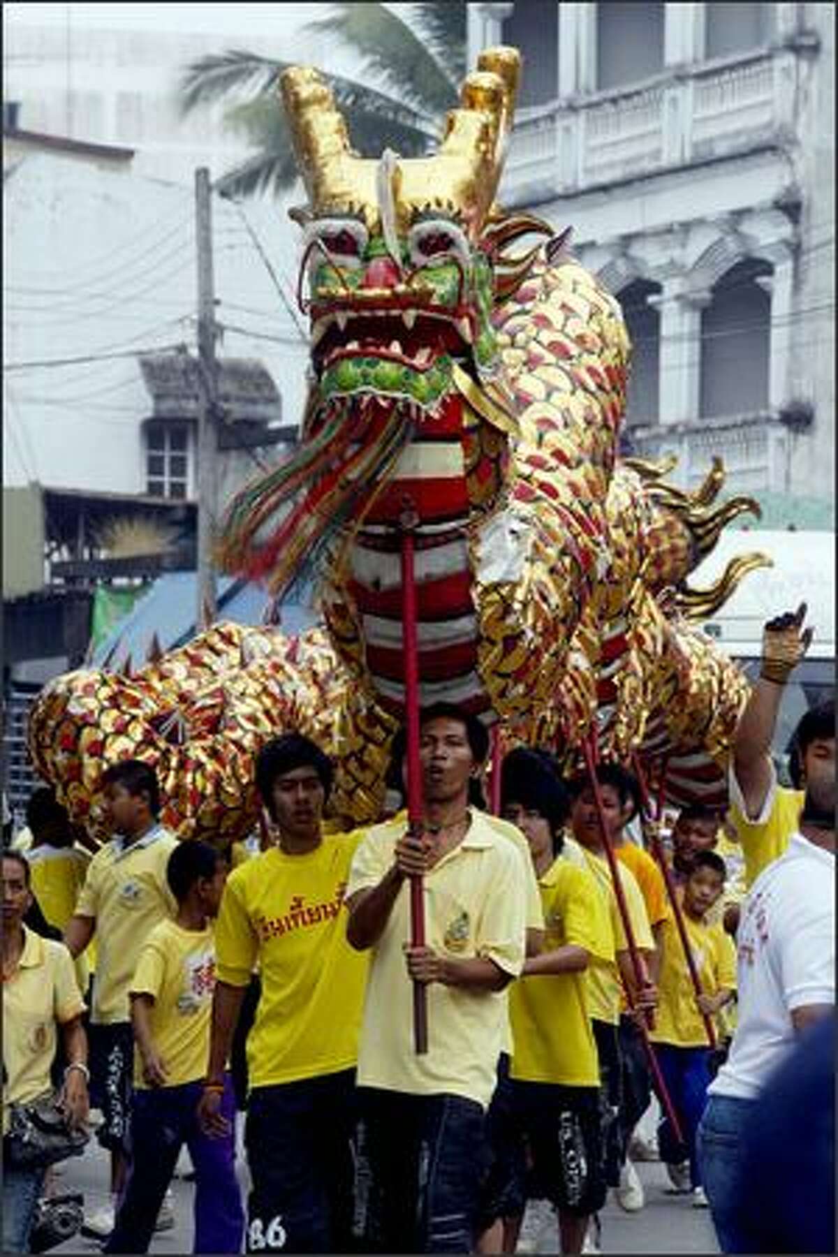 Thai entertainers parade a dragon outside a Chinese temple in Pattani, southern Thailand, on the eve of the Chinese New Year.