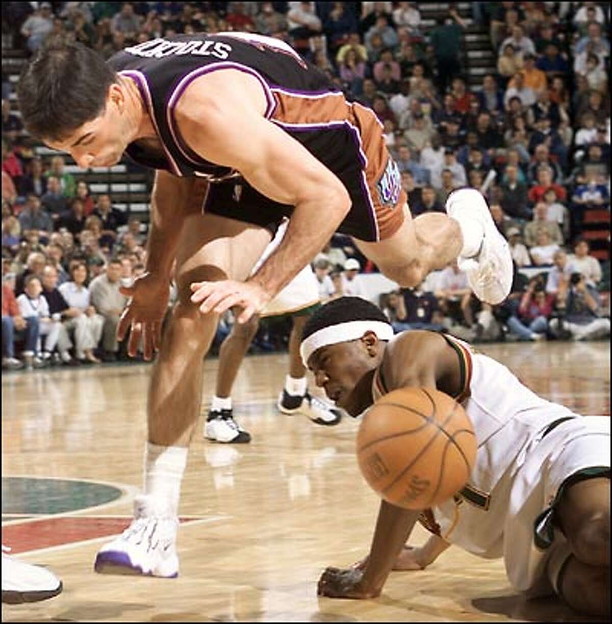 The Utah Jazz's John Stockton trips over Sonic Shammond Williams during a struggle for a loose ball in the second half of Game 3 of the first round of the NBA Playoffs in KeyArena.