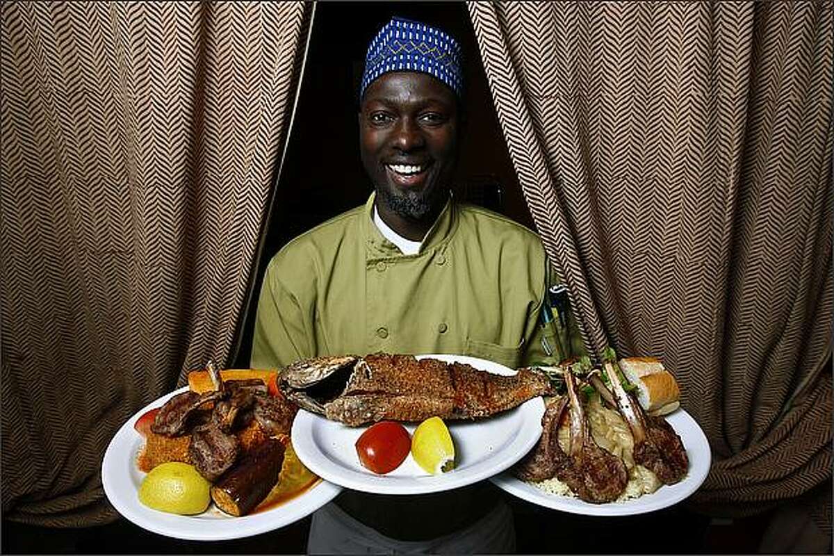 Jacques Sarr shows off his debe, grilled tilapia and yassa au poulet.