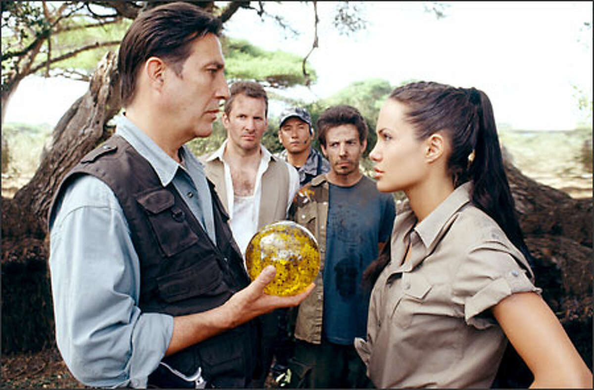 The villainous Jonathan Reiss (Ciarán Hinds) confronts Lara Croft (Angelina Jolie), her butler, Hillary (Christopher Barrie) and her assistant, Bryce (Noah Taylor).