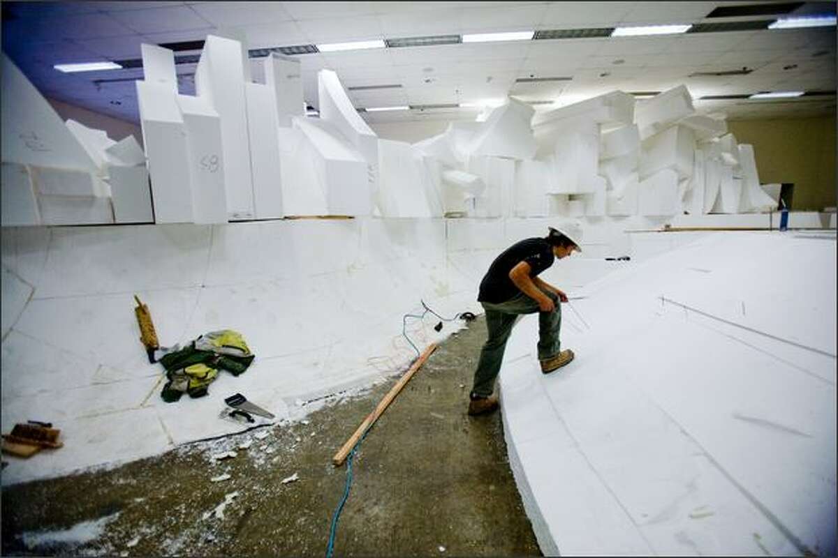 Joe Chopek works recently on a large puzzle of plastic foam that will become part of the new Seattle Center Skate Park. The park is billed as a 10,000 square-foot, state-of-the-art replacement for the popular spot torn down three years ago to make room for the Bill and Melinda Gates Foundation. Because it is being built on top of an underground kitchen, the base form of the park was made with the lightweight foam.