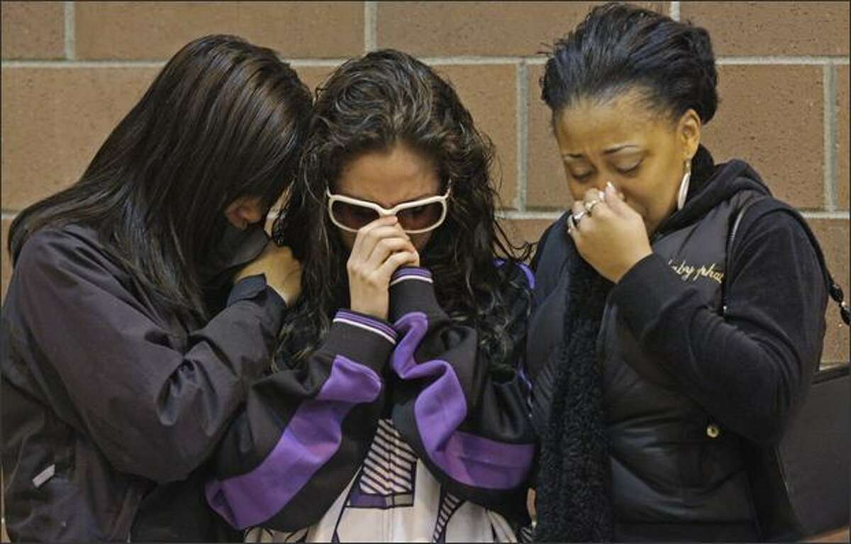 Young women comfort each other during a community rally held in response to the death of Tyrone Love, a Garfield High graduate, at the Garfield Community Center in Seattle on Saturday. Twenty-six-year-old Love, a popular party promoter, was gunned down in the Central District on Monday.