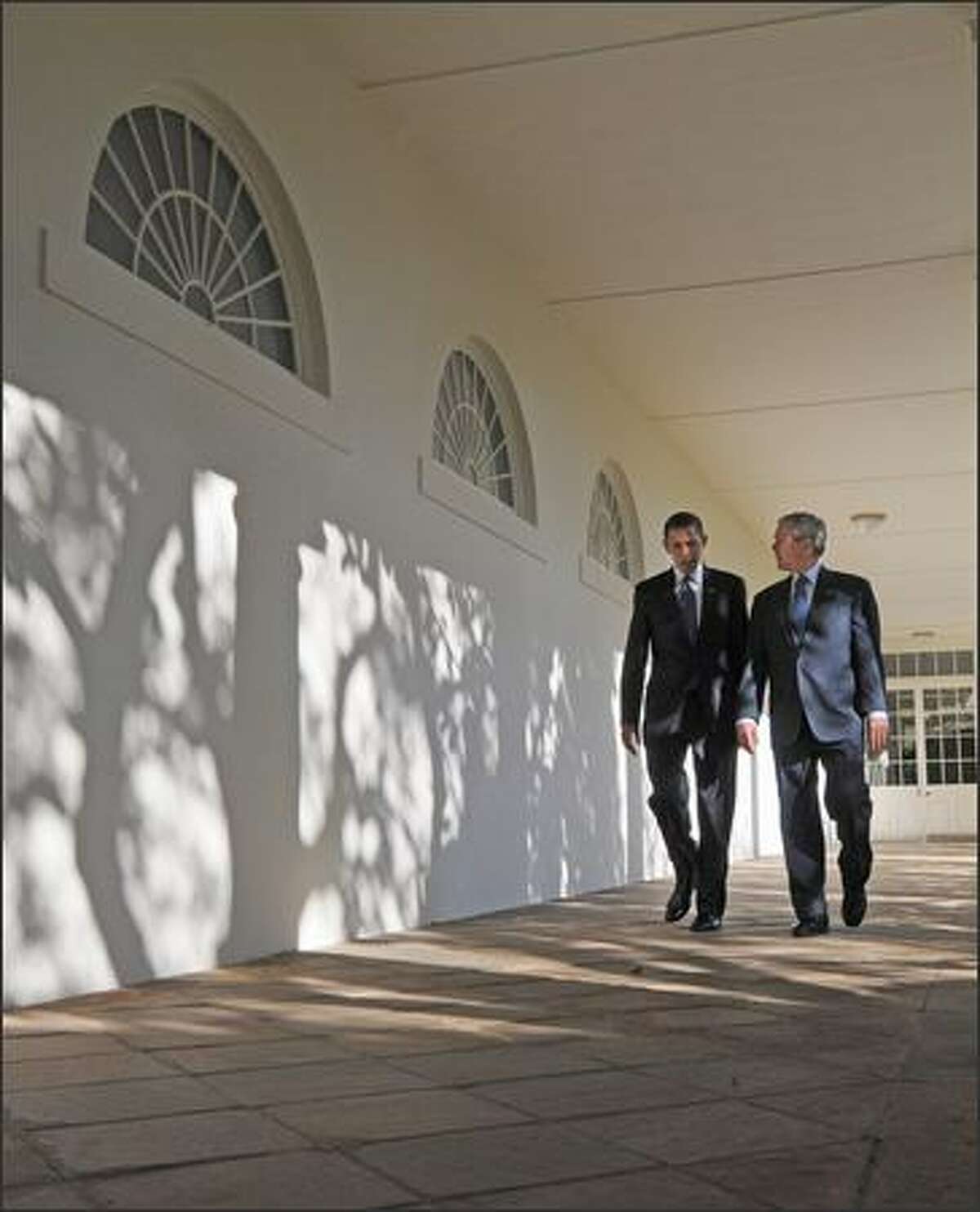 President George W. Bush and President-elect Barack Obama walk through the colonnade on Monday to the Oval Office at the White House in Washington, D.C.