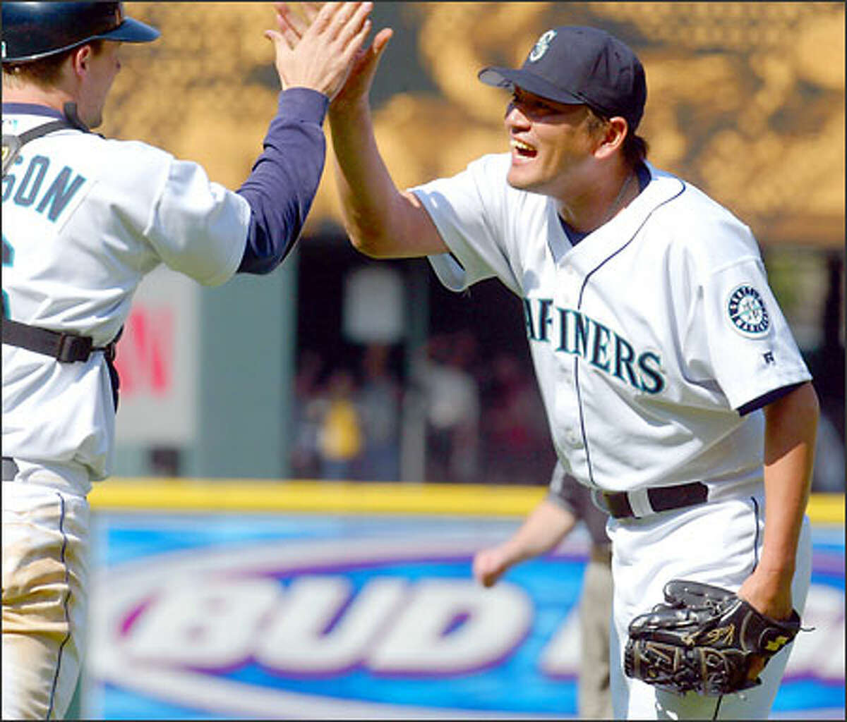 Mariners closer Kazuhiro Sasaki celebrates with catcher Dan Wilson after a victory over the White Sox at Safeco Field.