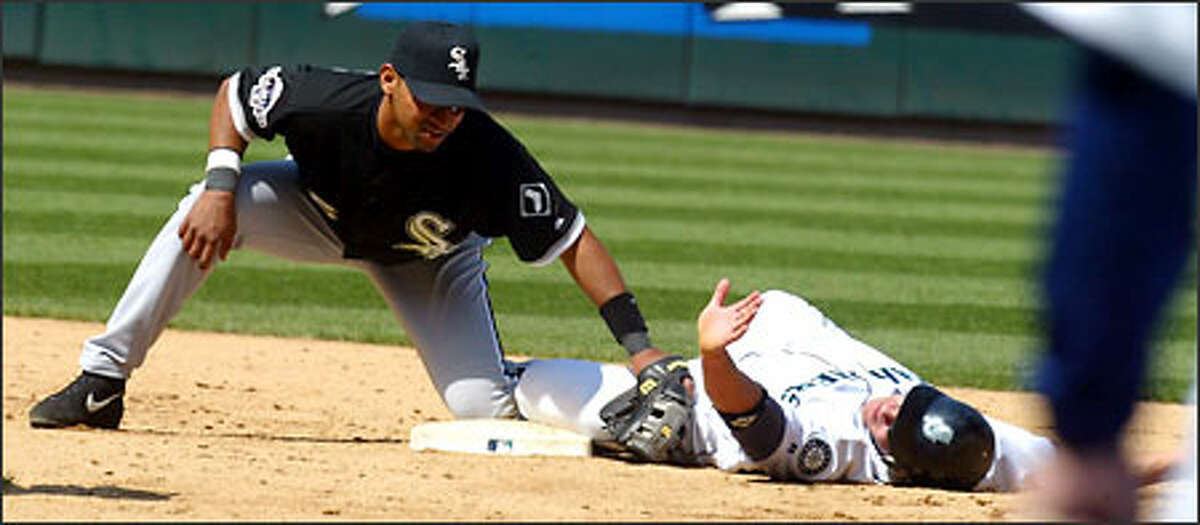 The Mariners' Bret Boone slides safely past the tag of White Sox second baseman D'Angelo Jimenez during the sixth inning.