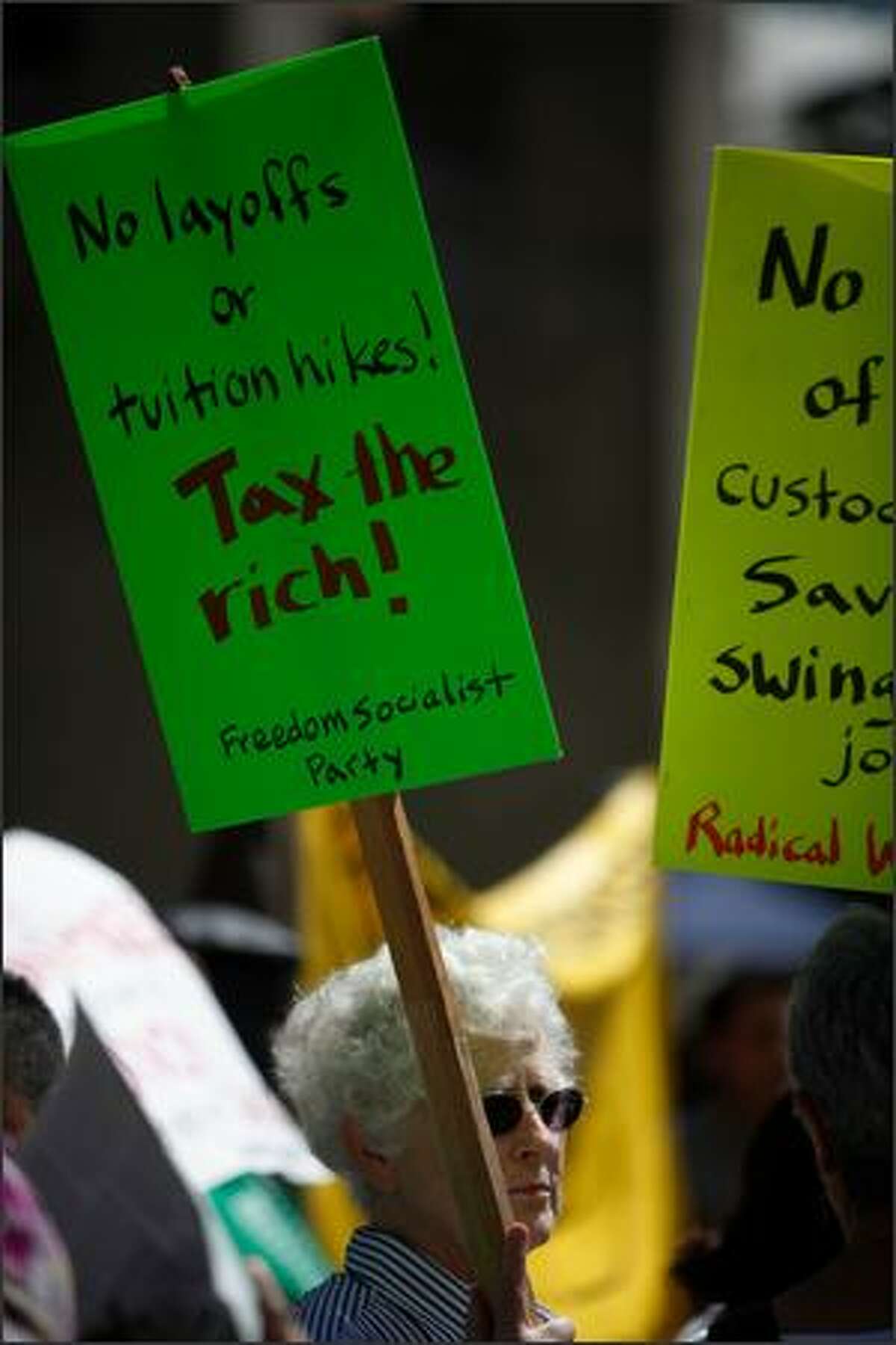 Protesters hold signs in Red Square during a rally against budget cuts and custodial swing shift eliminations at the University of Washington in Seattle, Wash. (May 28, 2009)