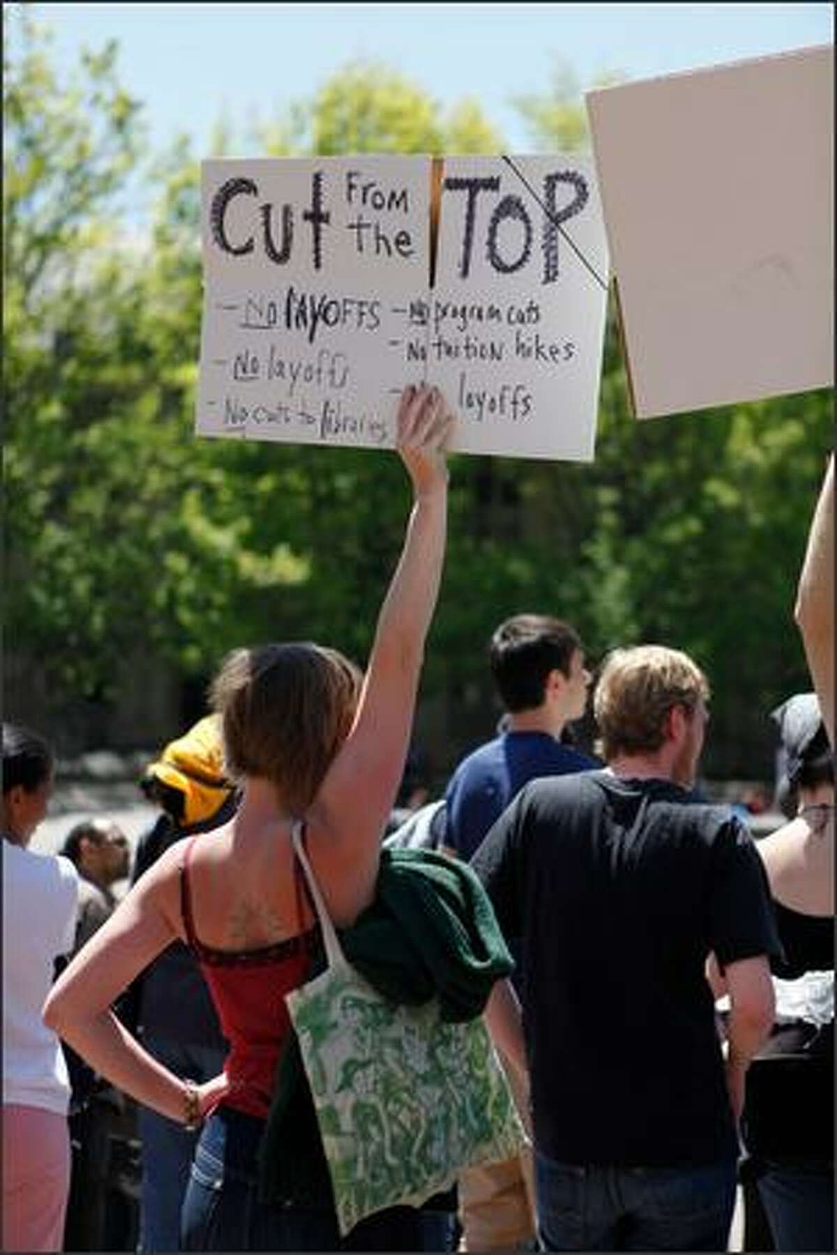 Protesters hold signs in Red Square during a rally against budget cuts and custodial swing shift eliminations at the University of Washington in Seattle, Wash. (May 28, 2009)