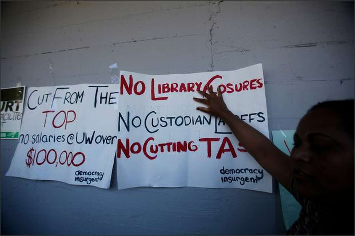 Signs are taped to the side of the Northlake Building during a rally against budget cuts and custodial swing shift eliminations at the University of Washington in Seattle, Wash. (May 28, 2009)