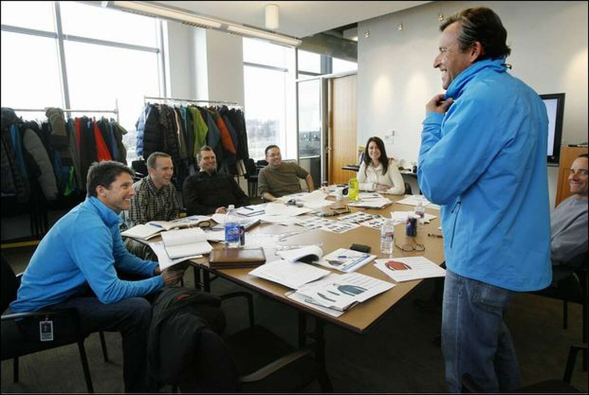 Mountain climber Ed Viesturs, second right, tries on a prototype of the FirstAscent midnight lite jacket Thursday as fellow climber Peter Whittaker, left, and others watch during a design team meeting at Eddie Bauer headquarters in Bellevue.