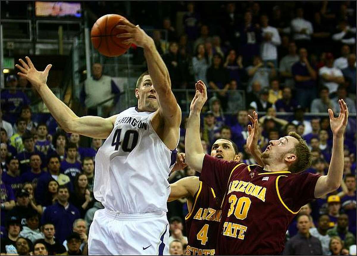 The UW's Jon Brockman goes up against Arizona State University players Jeff Pendergraph (4) and Rihards Kuksiks (30) to put the Huskies ahead in overtime on Thursday.
