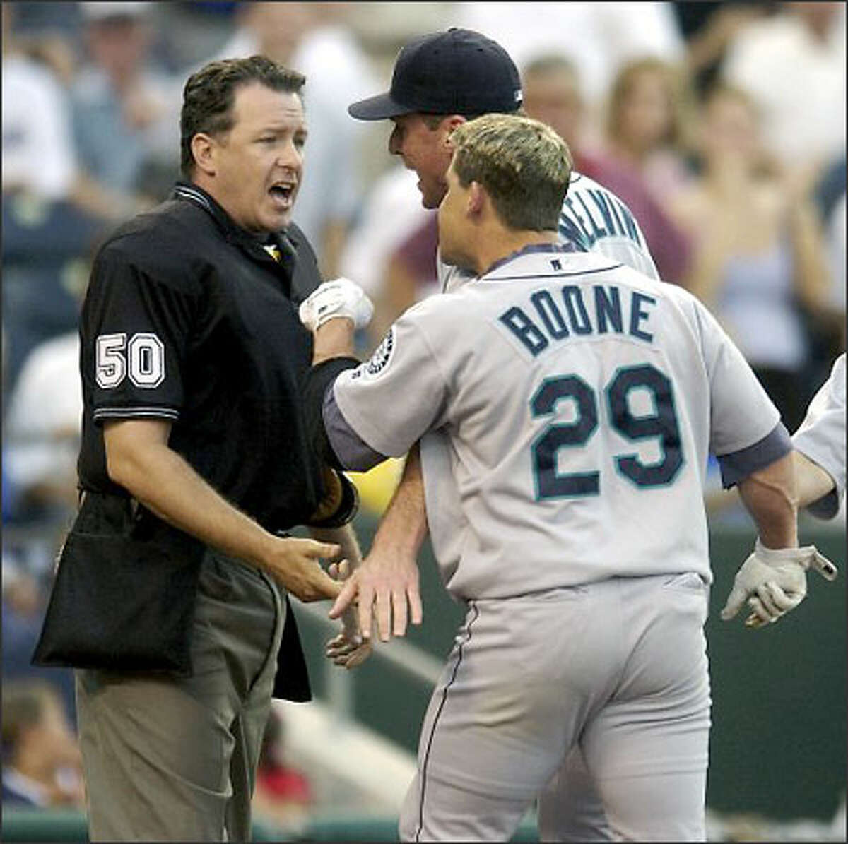 Mariners second baseman Bret Boone (29) and manager Bob Melvin argue with umpire Paul Emmel after Boone was ejected in the first inning against the Kansas City Royals. Boone, who struck out to end the inning, was ejected after he threw his bat and helmet while leaving the plate.
