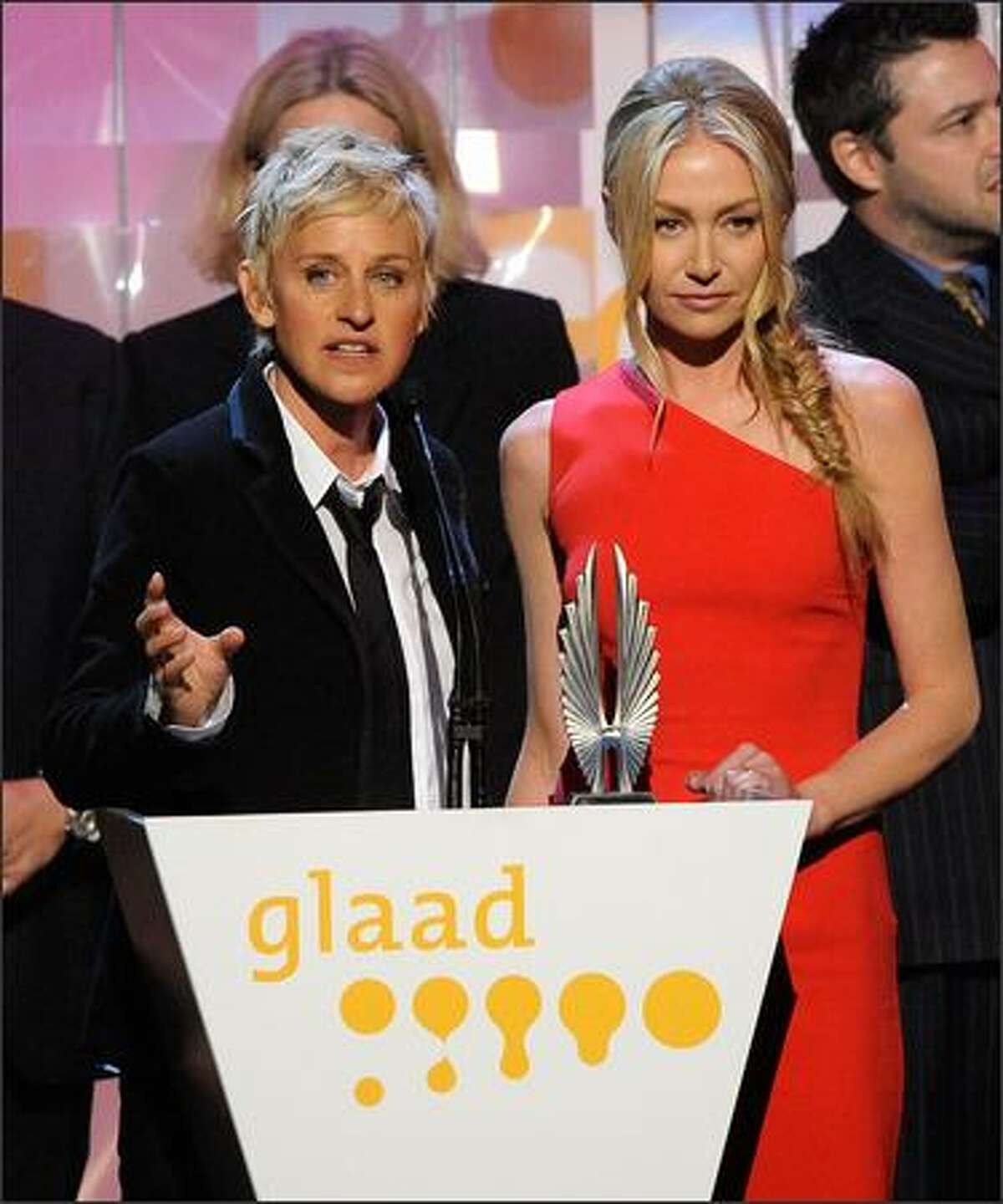 Actresses Ellen DeGeneres and Portia de Rossi speak onstage.