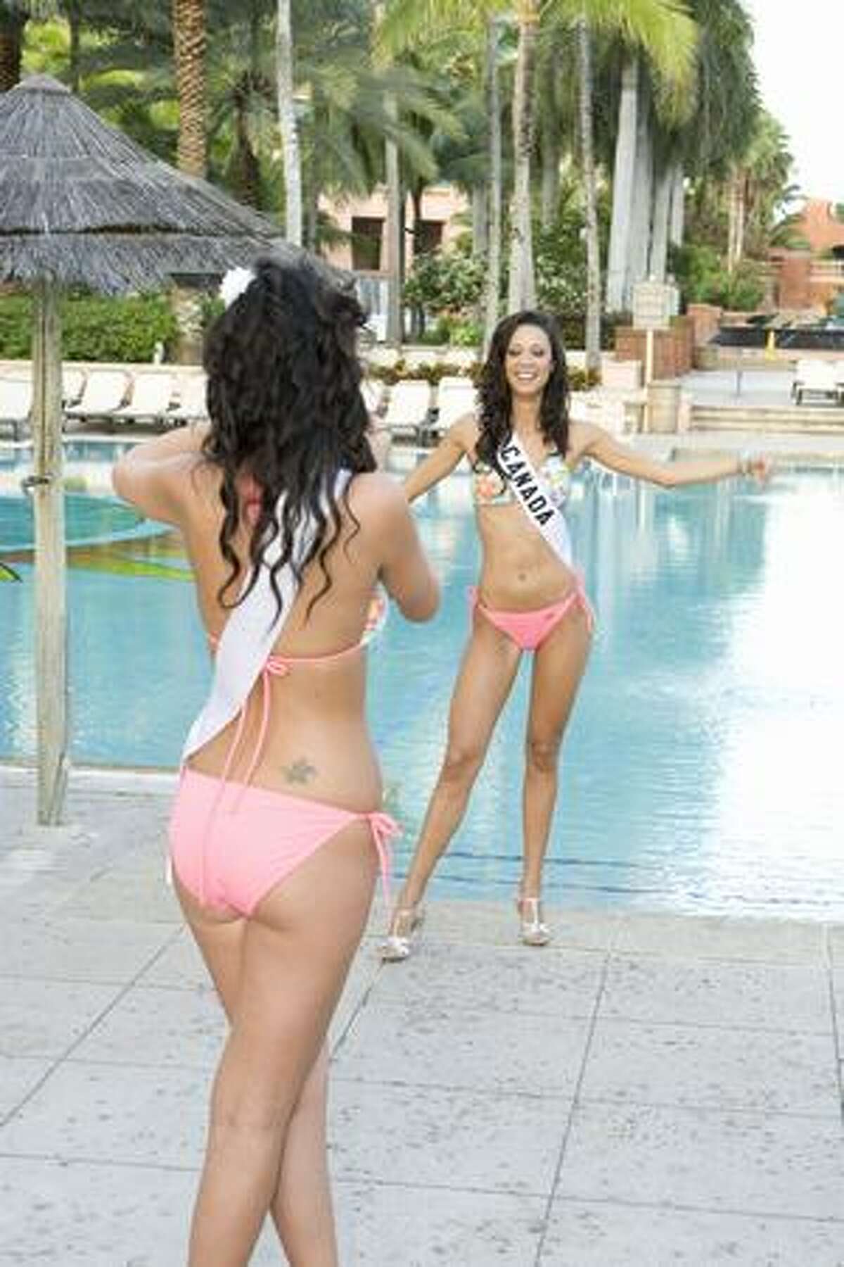 Dominique Peltier, Miss Bolivia, takes a photo of Mariana Valente, Miss Canada, at the Atlantis resort, headquarters for the pageant.