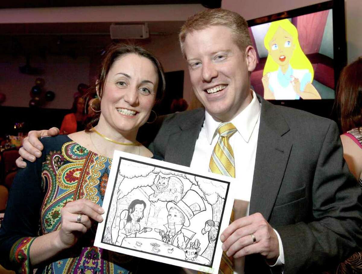 Tara Pleat, the museum board?s vice president, and Adam McNeill, the museum?s immediate past president, show off a cartoon portraying themselves as Alice in Wonderland and the Mad Hatter. Saratoga Springs, NY - March 19, 2011 (Photo by Joe Putrock / Special to the Times Union)