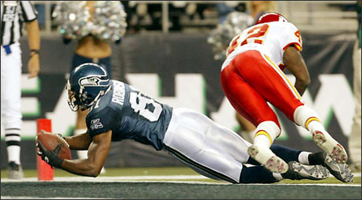 Seahawks Koren Robinson hauls in a 19 yard touchdown from Trent Dilfer in front of Chiefs Shaunard Harts during third quarter.