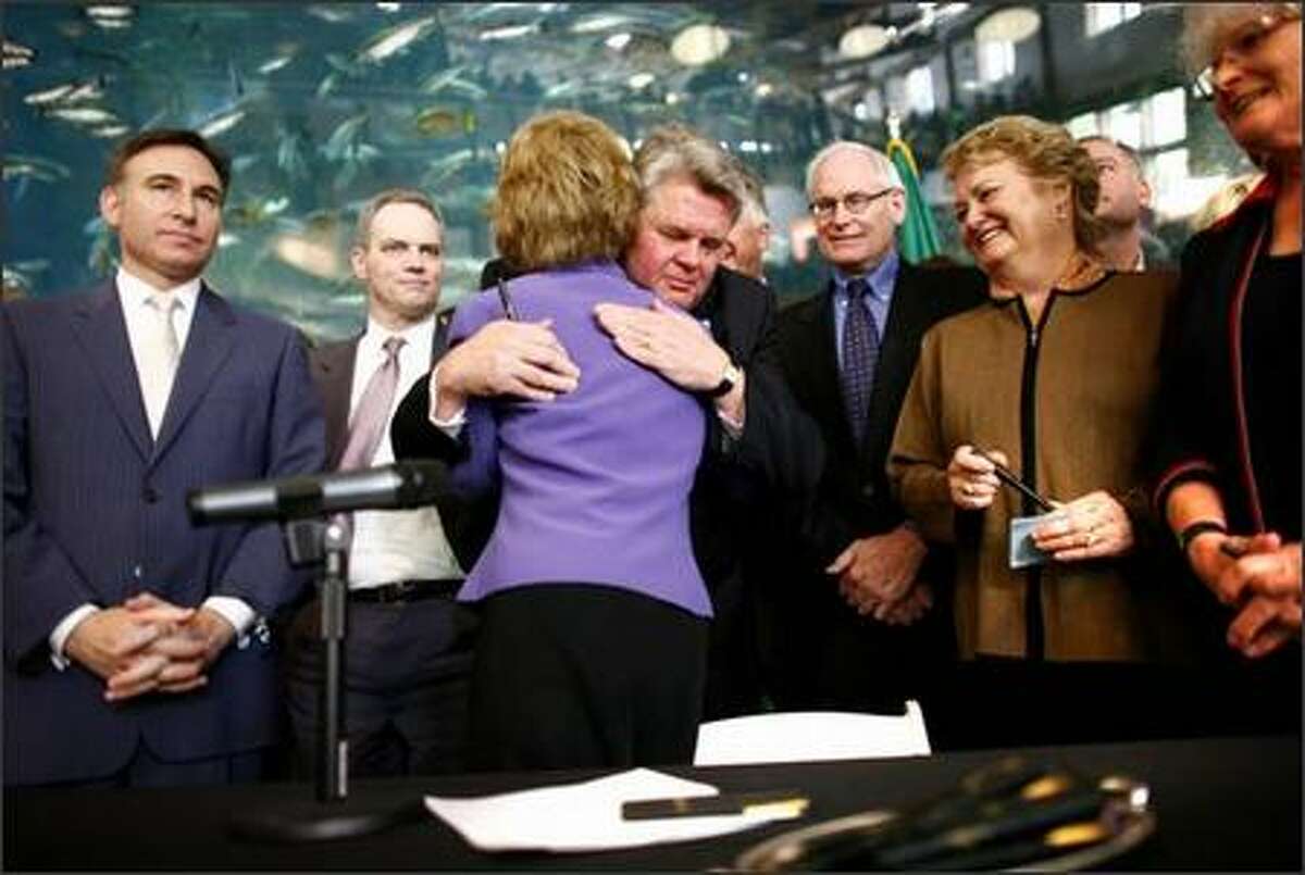 Gov. Chris Gregoire and Seattle Mayor Greg Nickels embrace after Gregoire signed legislation to replace the Alaskan Way Viaduct on Tuesday.
