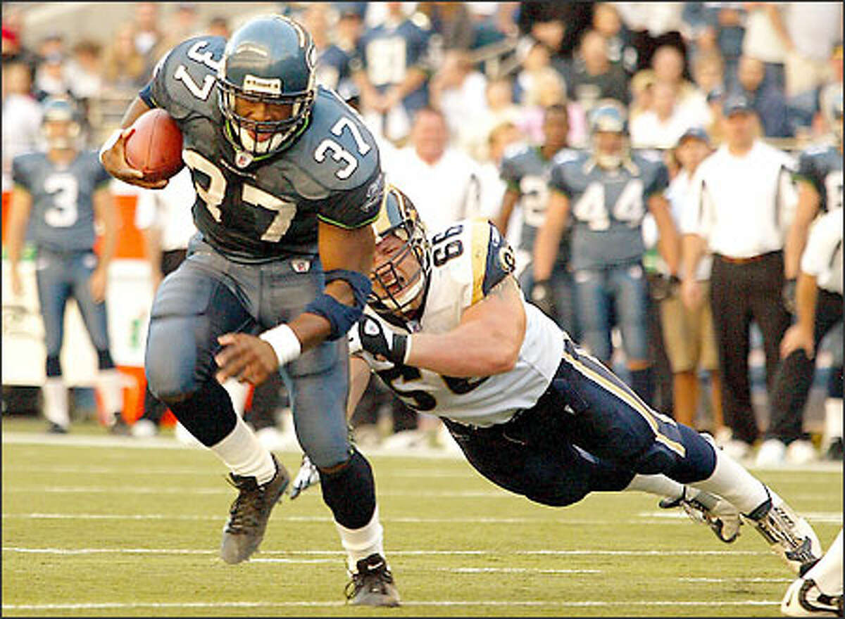 Shaun Alexander eludes the Rams' Brian Young to gain five yards. Alexander's wife, Valerie, delivered the couple's first child, Heaven, early yesterday afternoon. "I got to pull the baby out and I got to cut the cord. That was my first catch of the day," Alexander said.