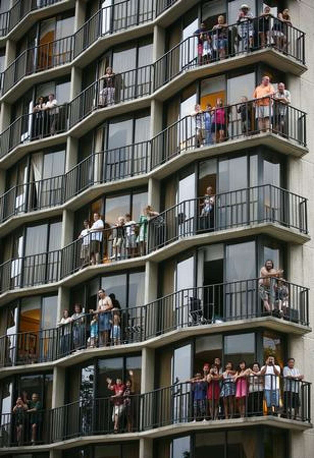 People watch the parade from the Warwick Hotel during the Seafair Torchlight parade on Saturday July 25, 2009 along 4th Avenue in Seattle.