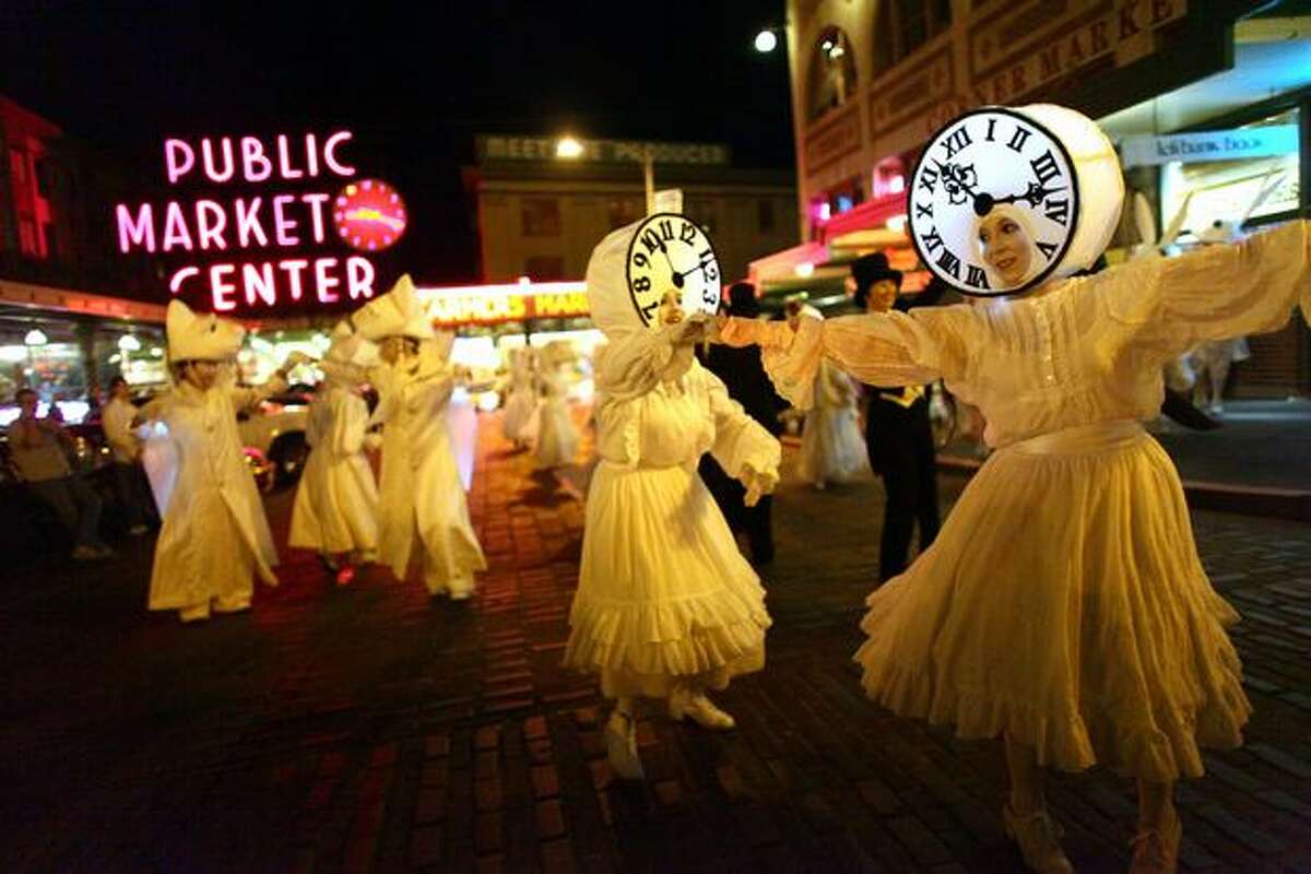 Performers in Lullaby Moon, a show celebrating the new moon, perform in front of Pike Place Market on Thursday.