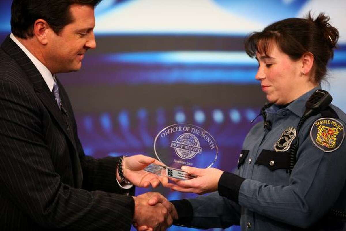 Seattle Police Officer Britt Sweeney is awarded Officer of the Month award by Washington's Most Wanted host David Rose at the Q13 FOX studios. Assistant Chief Nick Metz said Sweeney has faced some significant challenges early in her career and has done an amazing job dealing with a tough situation.