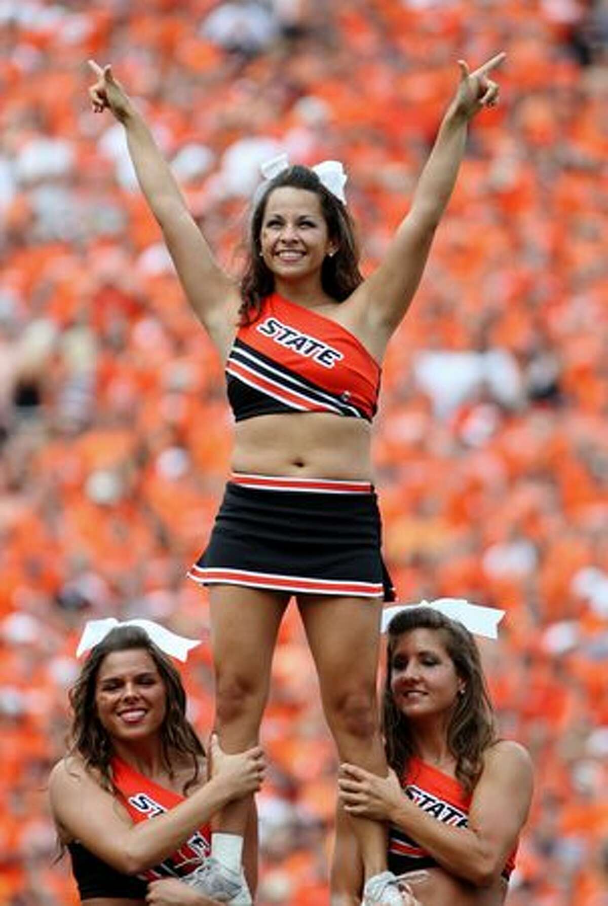 Cheerleaders from Oklahoma State University perform from the sidelines during the first quarter of a game against Georgia in September. Cheerleading is recognized as a sport on most U.S. college campuses and carries with it elements of danger and injury risk that sometimes outweigh those of other collegiate sports. All of the photos in this gallery are from collegiate games played this season.
