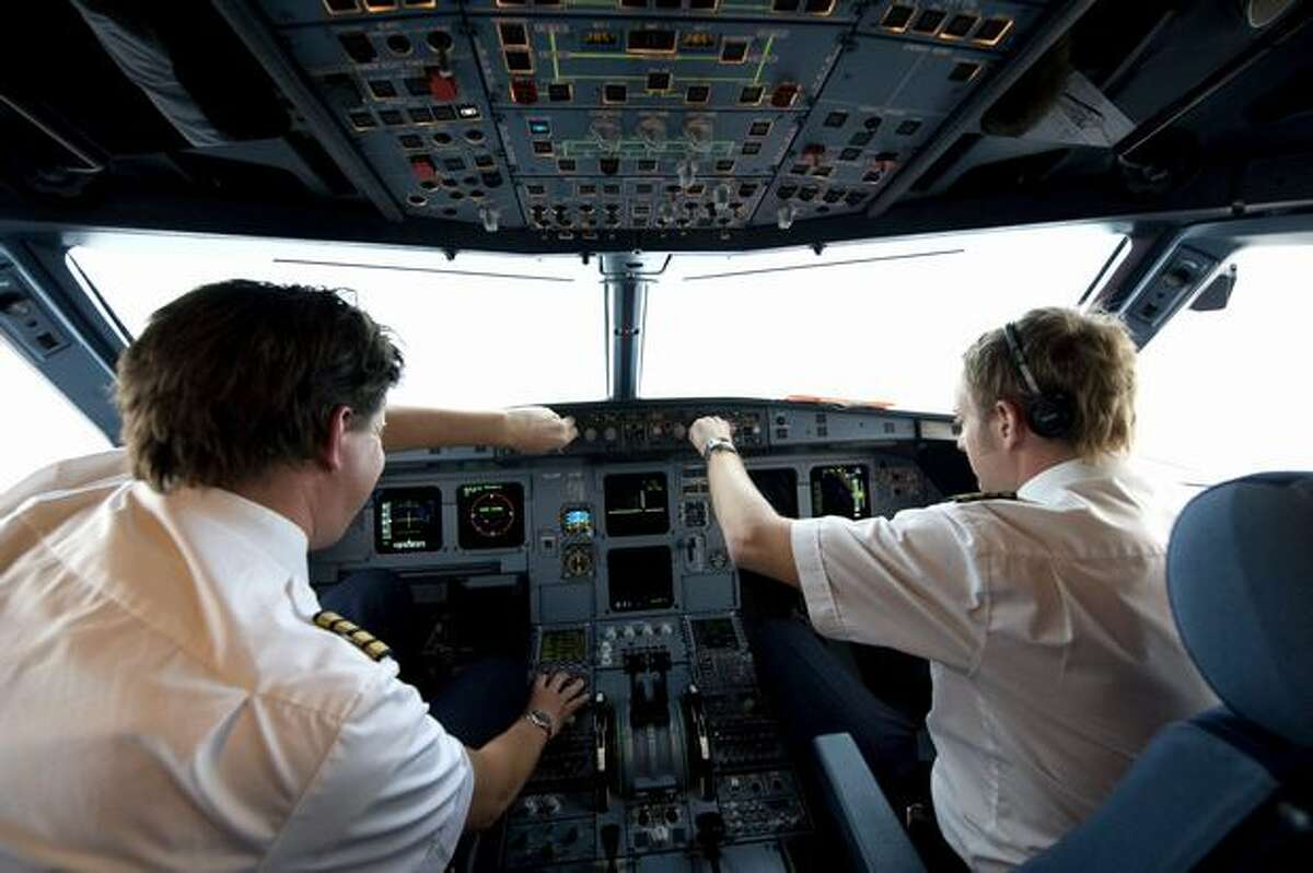 Pilots Henrik Ekstrand (left) and Andreas Liner of Novair Airline demonstrate a new approach technique flying an Airbus A321 to Arlanda airport in Stockholm, Sweden, on Nov., 25, 2009.(PONTUS LUNDAHL/AFP/Getty Images)