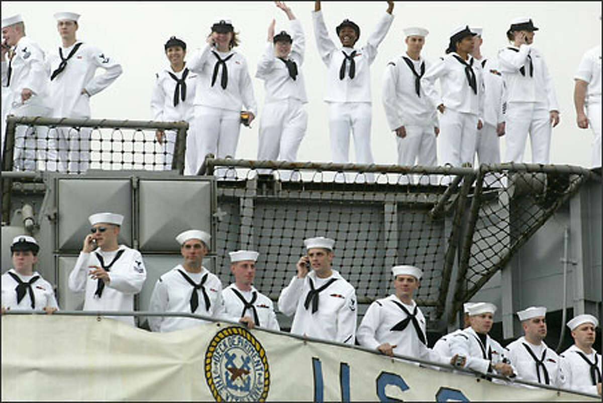 Sailors on board the USS Carl Vinson wave to the crowd upon their return to Bremerton after eight months at sea.