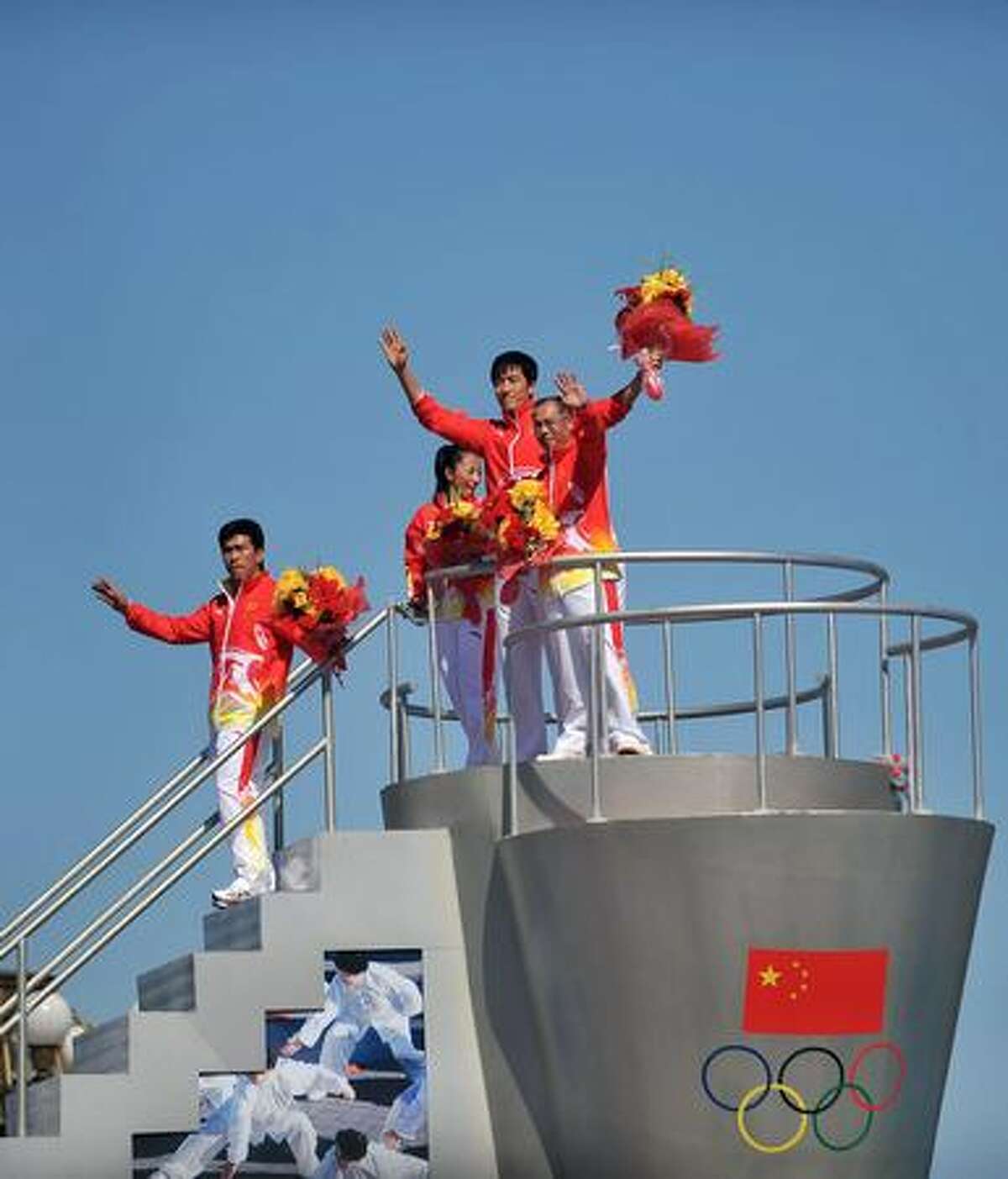 China's top hurdler Liu Xiang together with other Olympic heroes wave from top of a float during the National Day parade in Beijing.
