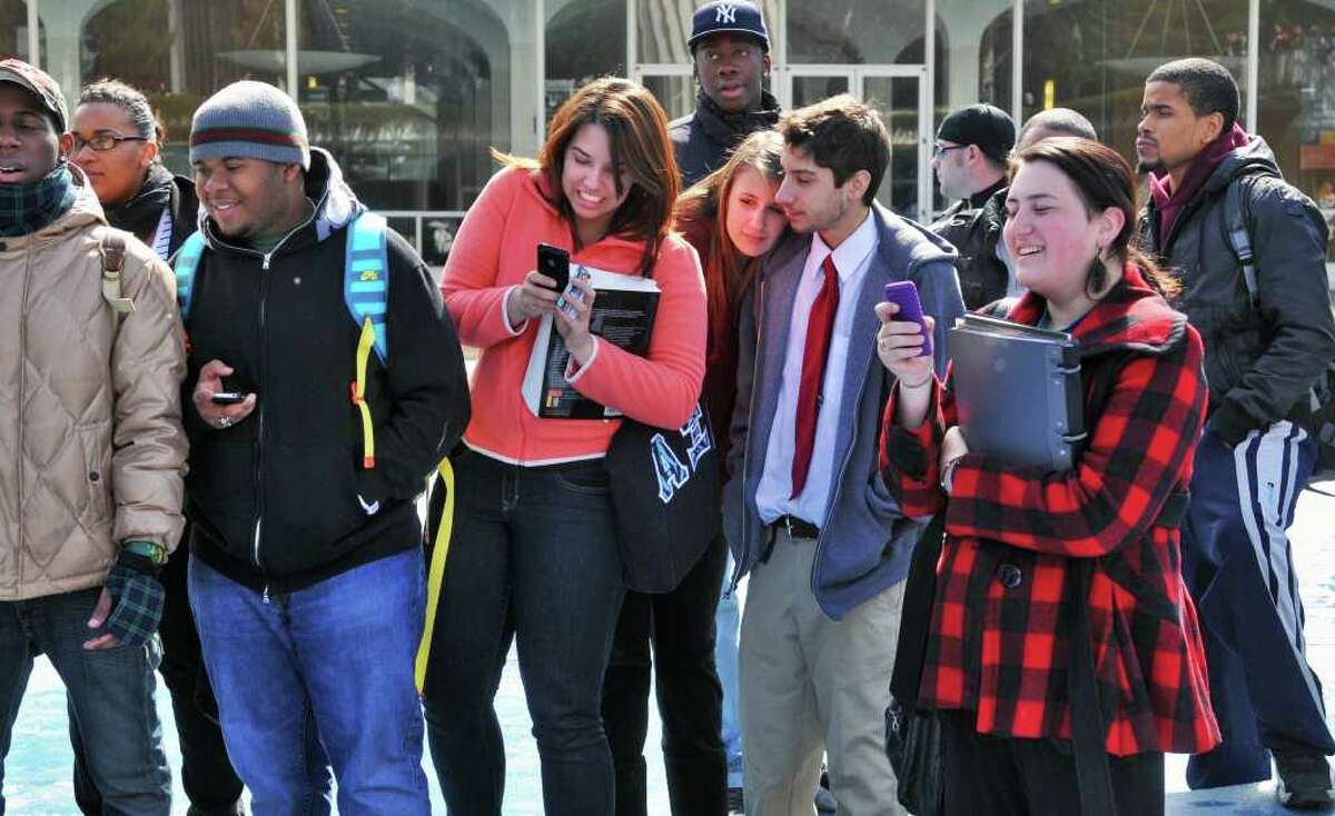 A small group of UAlbany students look on as fellow student and veteran, Chris Schewe, 41, of Pittstown is chained to the fountain at UAlbany's main campus in Albany Friday morning March 25, 2011. (John Carl D'Annibale / Times Union)
