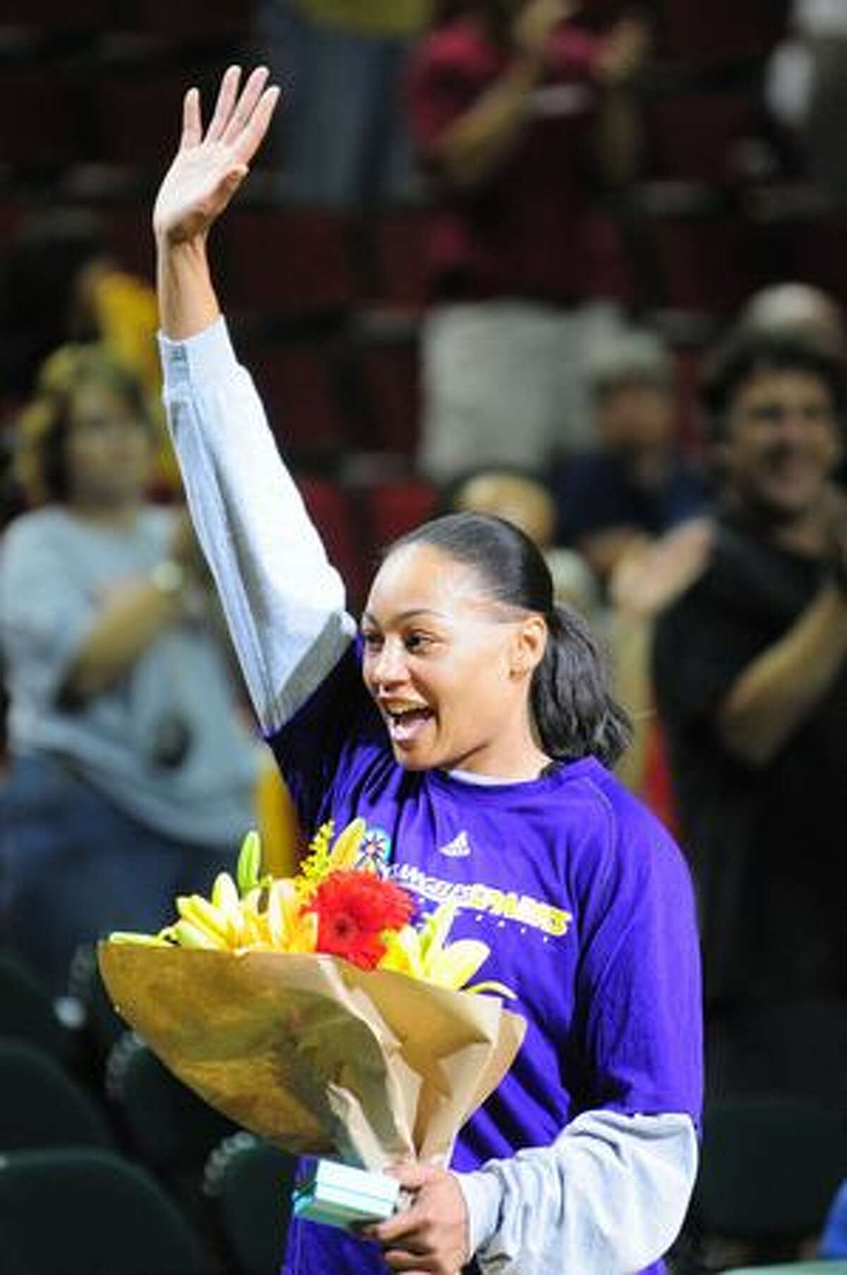 Betty Lennox of the Los Angeles Sparks waves to the crowd after being presented with flowers by Seattle Storm CEO Karen Bryant at the start of the game Wednesday July 23, 2009.