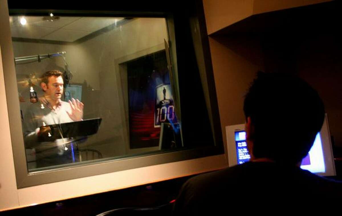 Host Chris Cashman performs in the sound booth as lead producer Oren Stambouli looks on during Tuesday's live production of "1 vs. 100," an interactive game show on Microsoft's Xbox 360.