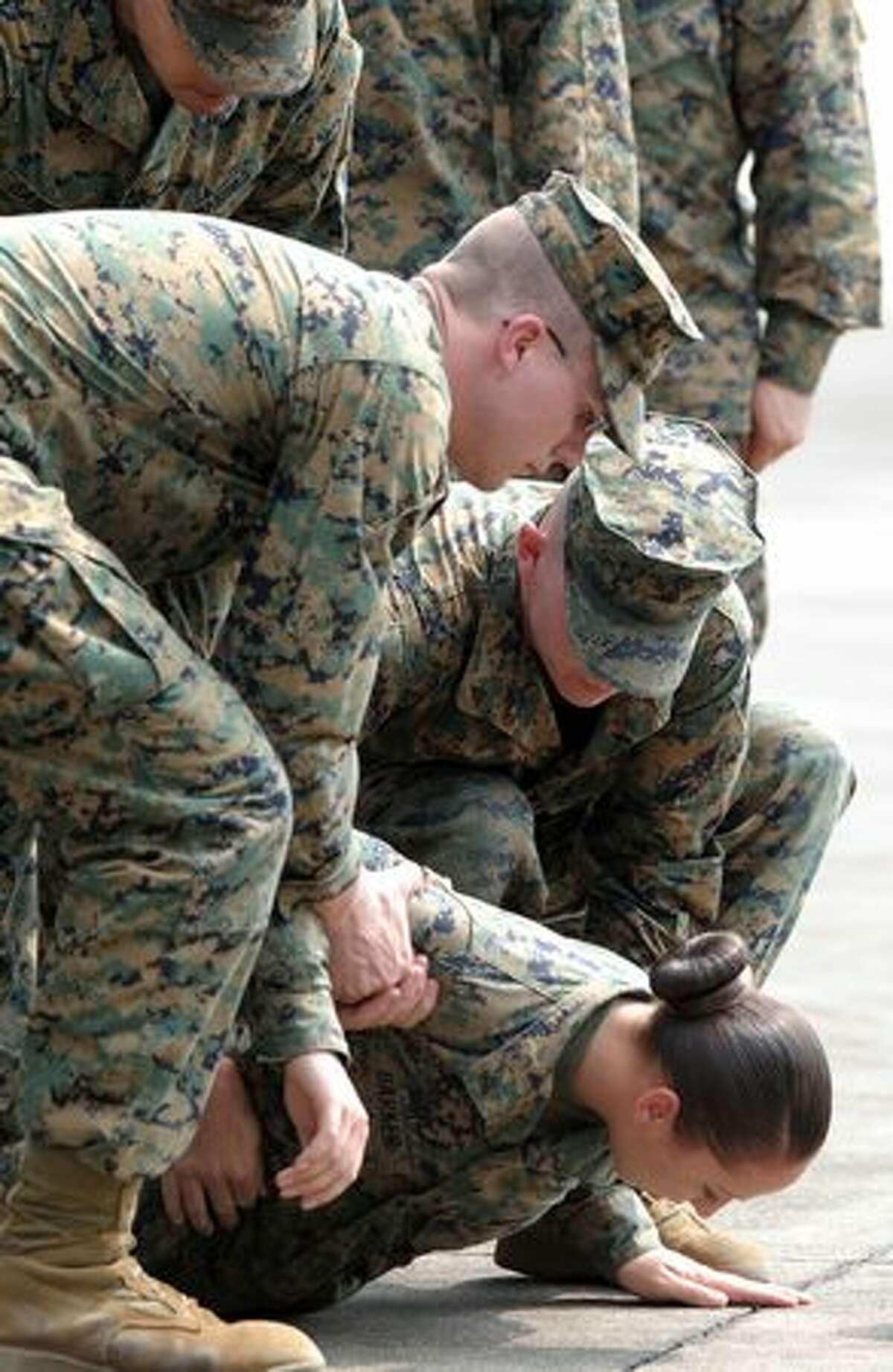 A member of the U.S. Marines is helped up by colleagues after fainting during the opening ceremony of the annual combined military exercise Cobra Gold 2010 at U-Tapao airport in Rayong province, Thailand, on Feb. 1, 2010.
