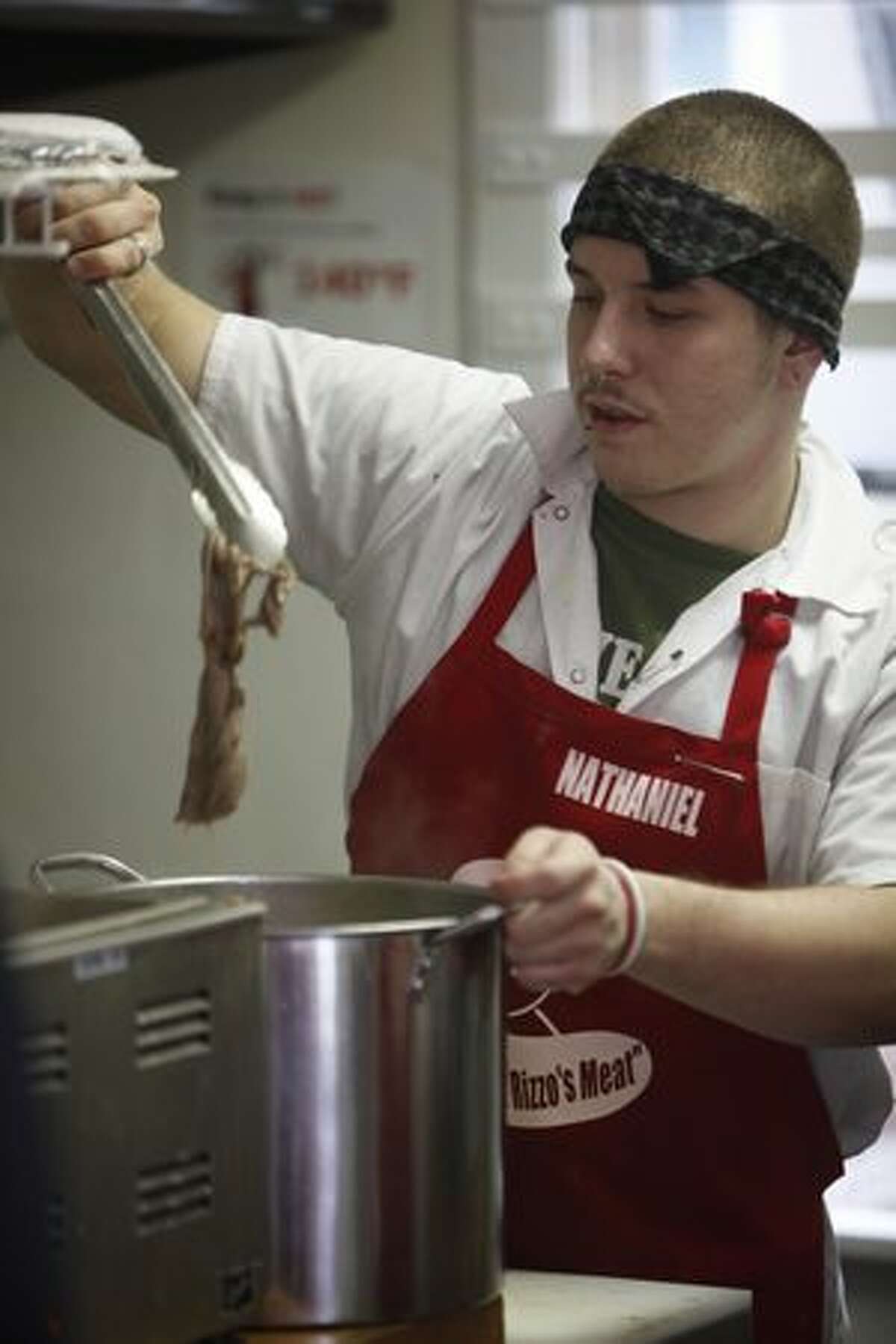 Nathan Grier prepares meat for french dips. Grier had been homeless since he was 17 until 10 months ago when Rizzo hired him to do odd jobs. He has since found a place to live and has worked as a cook at Rizzo's French Dip since it opened five months ago.