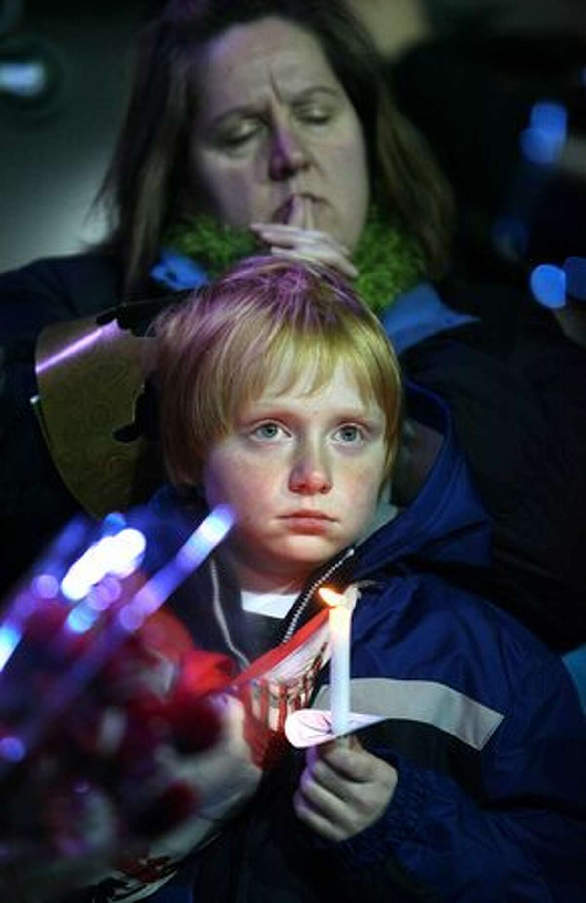 Kelly Groenwold and her son Aaron, of Lakewood, Wash., participate during a candlelight vigil on Wednesday December 2, 2009 at the Lakewood Family YMCA in Lakewood, Wash. Thousands gathered to pay their respects to four Lakewood Police officers who were shot and killed at a coffeepot Sunday morning in Parkwood.