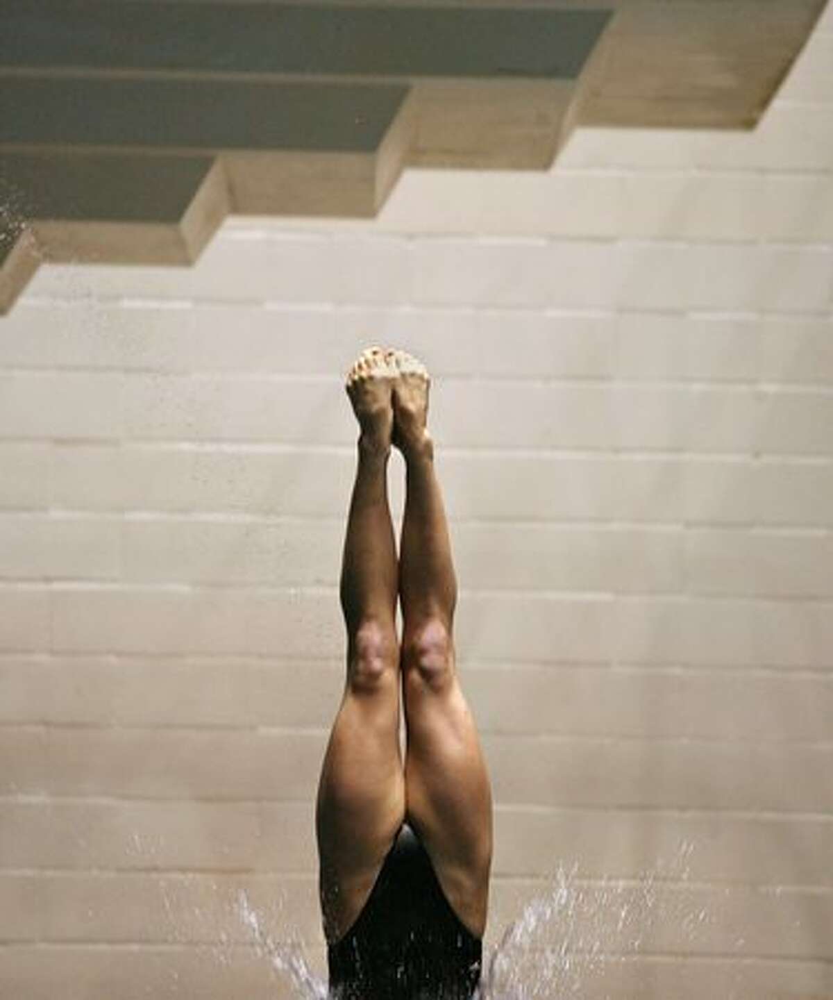 A diver enters the water during the women's three-meter preliminary diving competition. The PAC-10 diving championships are being held this weekend at the Weyerhaeuser-King County Aquatic Center in Federal Way. Competition continues through Saturday. (David Ryder/Seattlepi.com)