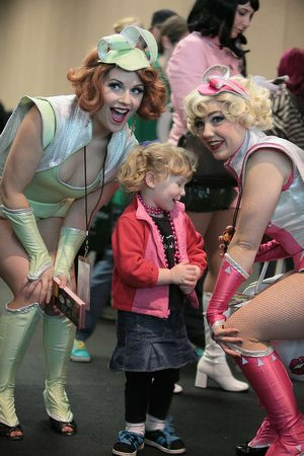 Baylyn Savage, 2, poses with members of the Atomic Bombshells during Emerald City ComiCon.