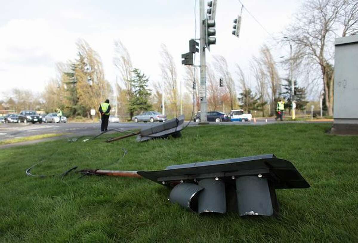 A traffic control light rests on the side of the road after falling into the intersection of Northeast 44th Street and Montlake Boulevard Northeast during a strong windstorm on Friday April 2, 2010. Power was knocked out to thousands of homes and businesses across the region because of the high winds.
