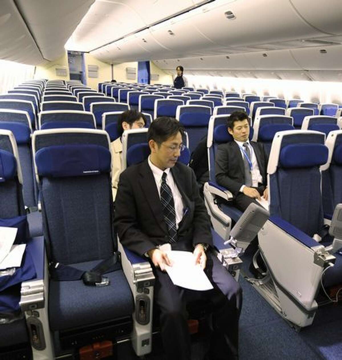 Employees of Japan's All Nippon Airways introduce economy-class seats in the company's new Boeing 777-300ER during a press preview at an ANA hangar in Narita International Airport, suburban Tokyo on April 16, 2010. The new aircraft is scheduled to commence flights from April 19 on the Narita-New York route.