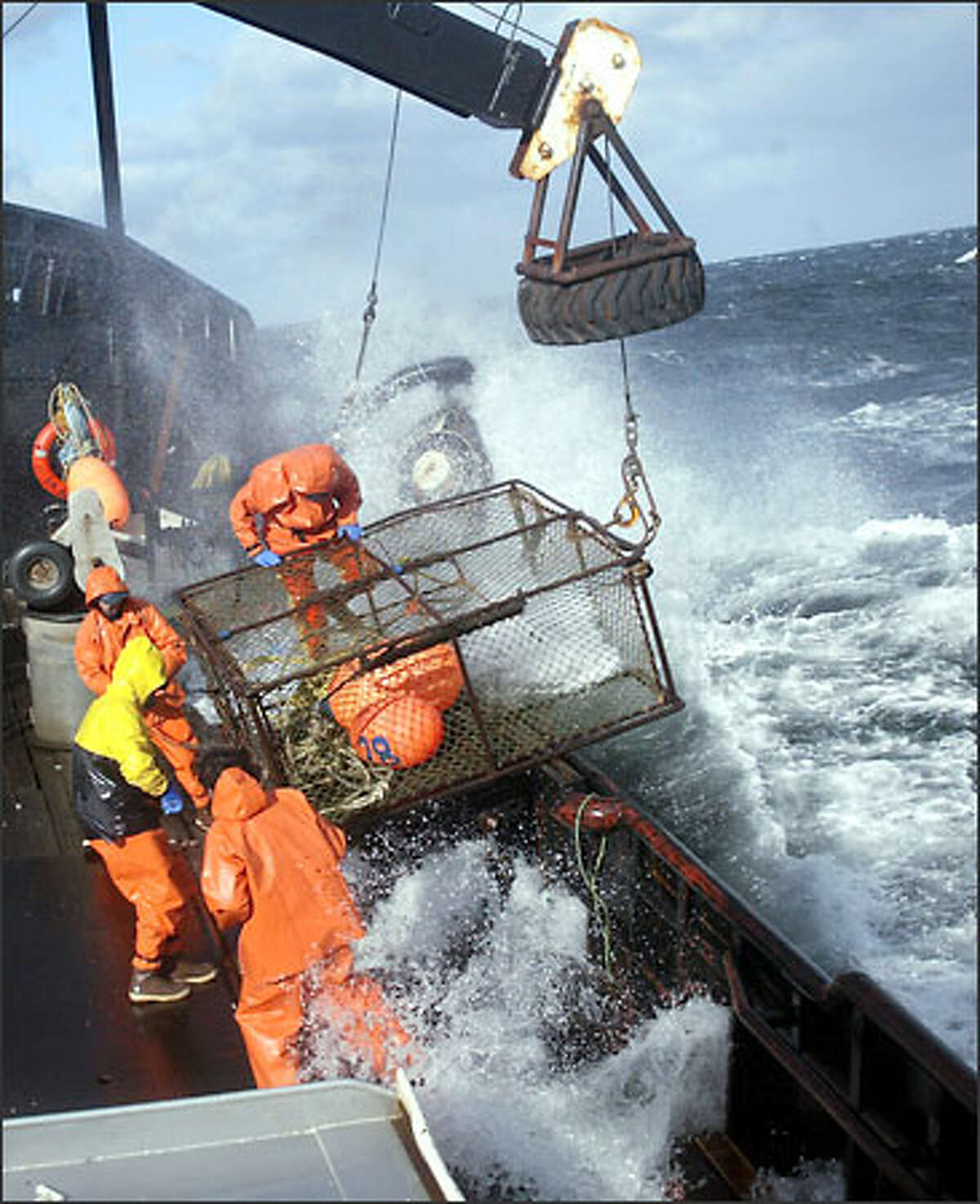 Crewmen ready a crab pot to be stacked on board the F/V Exito while fishing for red king crab in Bristol Bay. The 2003 season lasted five days and two hours, and was plagued with gale-force winds of 35 knots or higher almost every day.